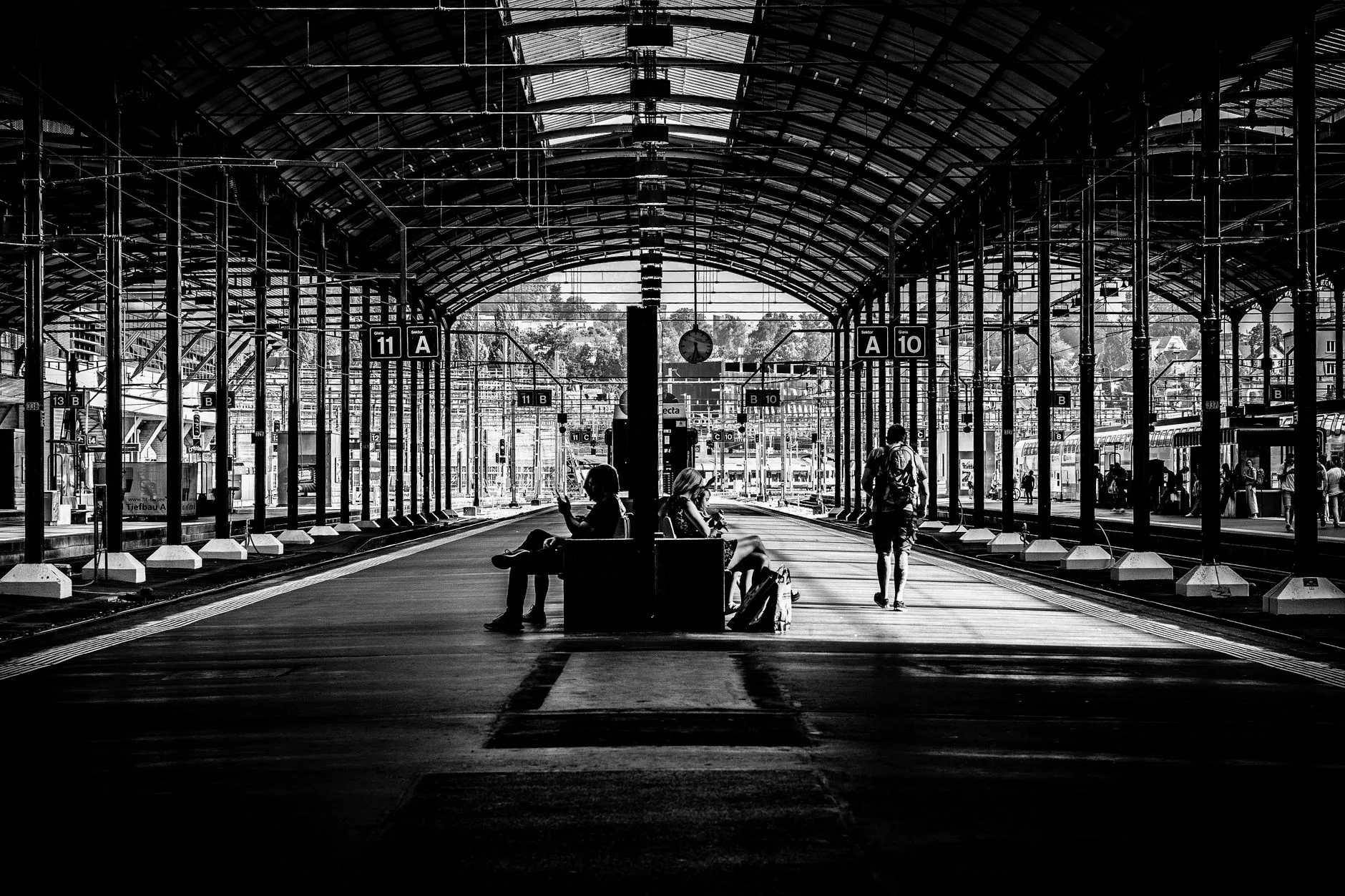 Modern sırt çantası ile tren istasyonunda bekleyen bir gezgin