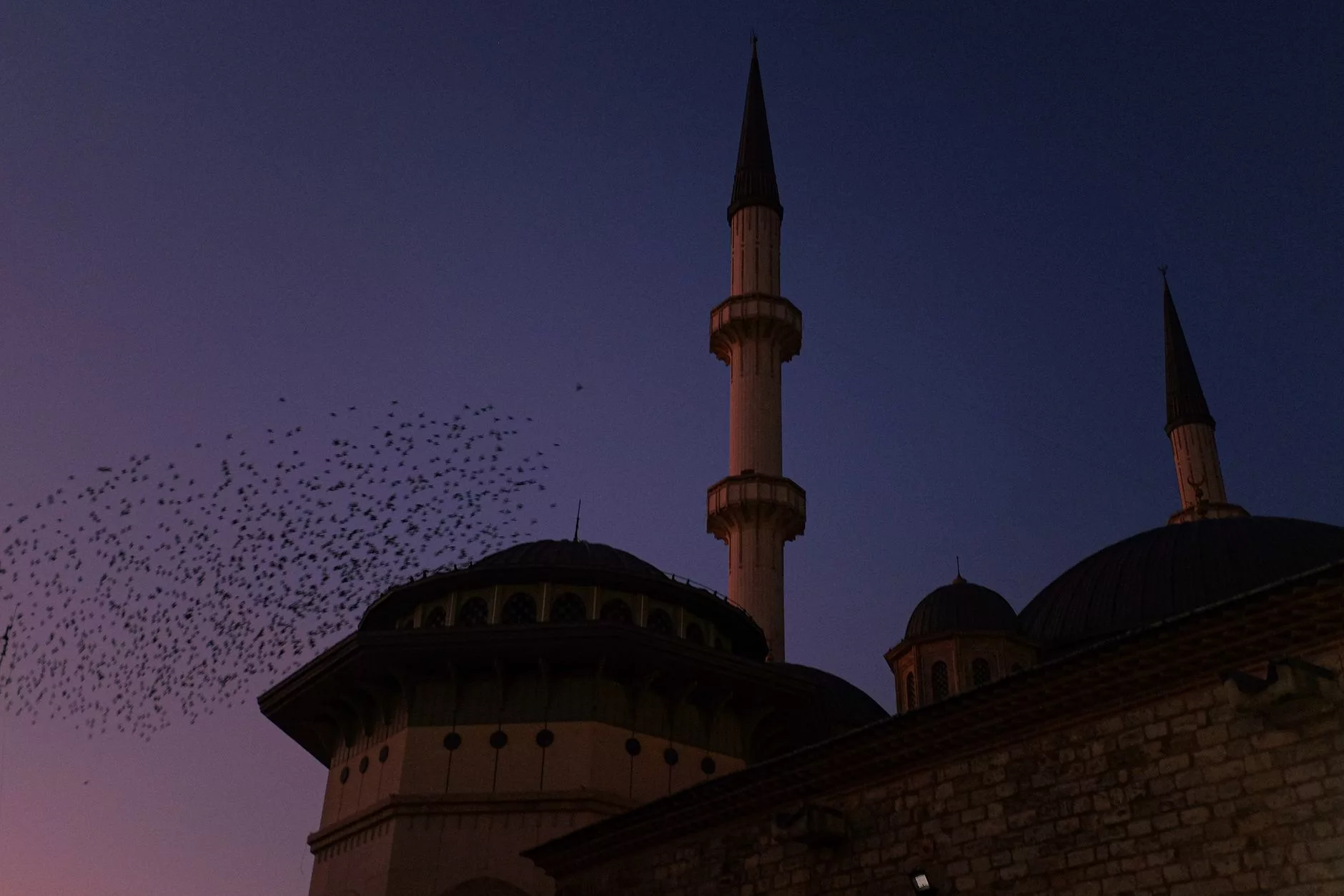 Başçarşı meydanında gün batımı ve güvercinlerin uçuştuğu tarihi sebilin detaylı görünümü