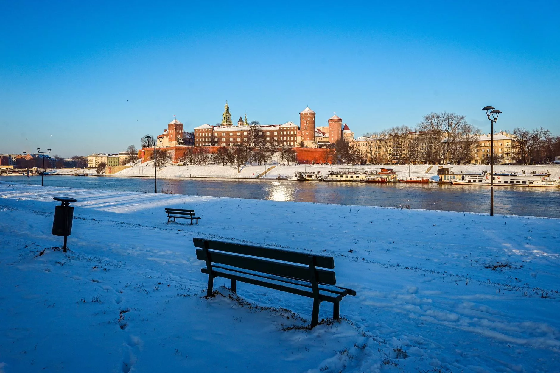 Krakow'un Vistül Nehri kıyısında gün batımı ve Wawel Kalesi manzarası
