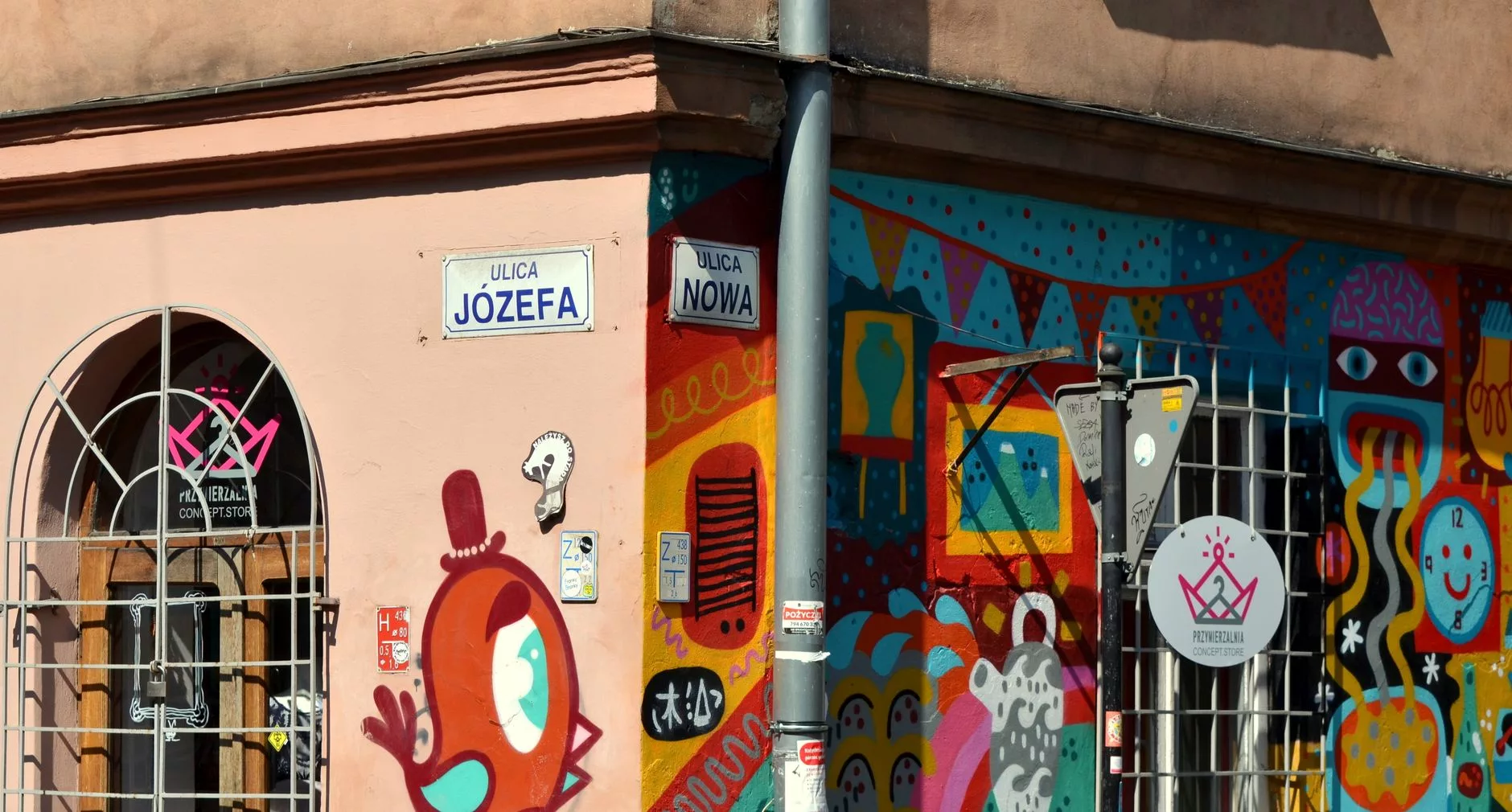 Krakow ara sokaklarında renkli tabelalı kahve dükkanları ve bisikletliler