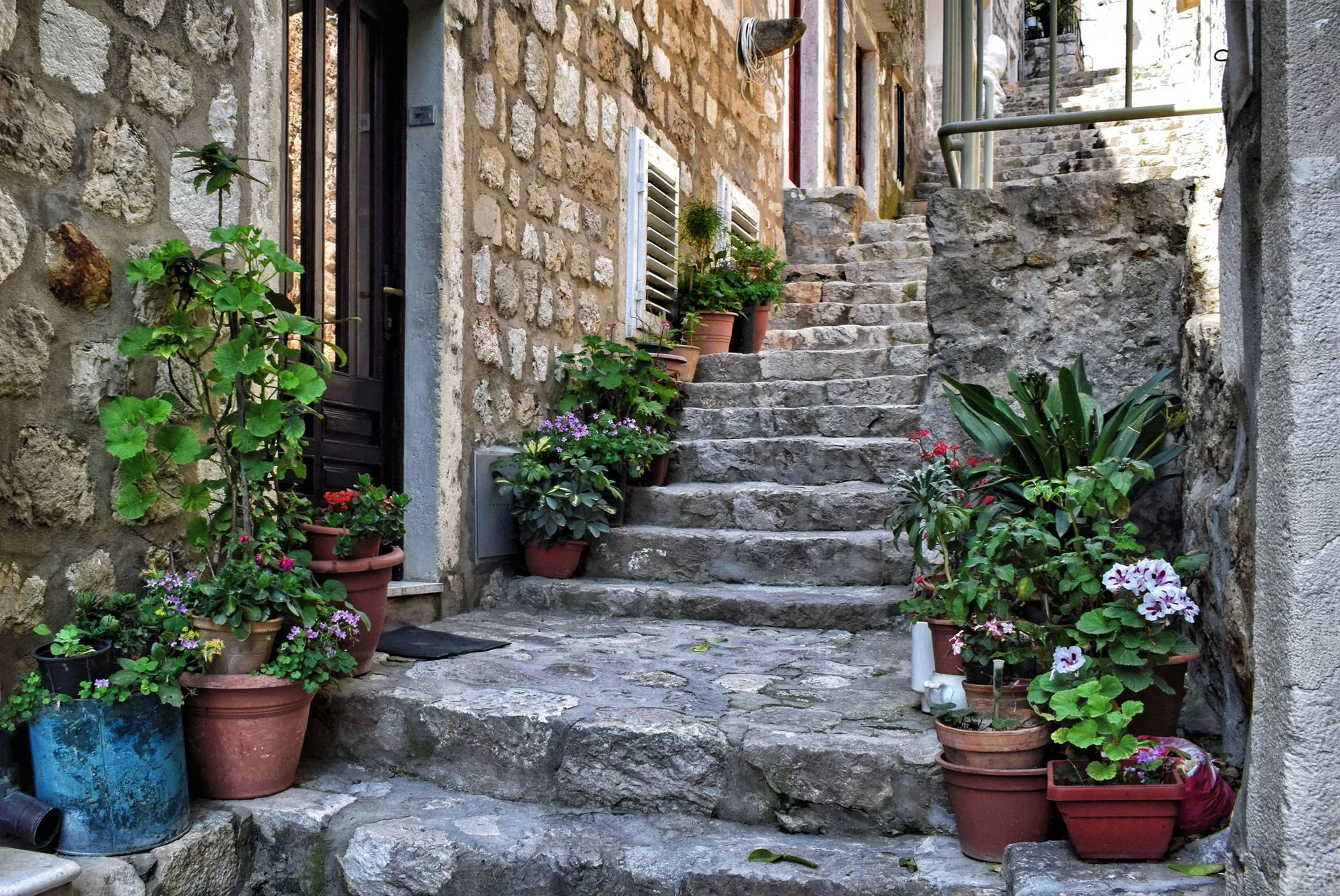 Dubrovnik, dar ara sokaklarda gölgeli merdivenler ve çiçekli balkonlar