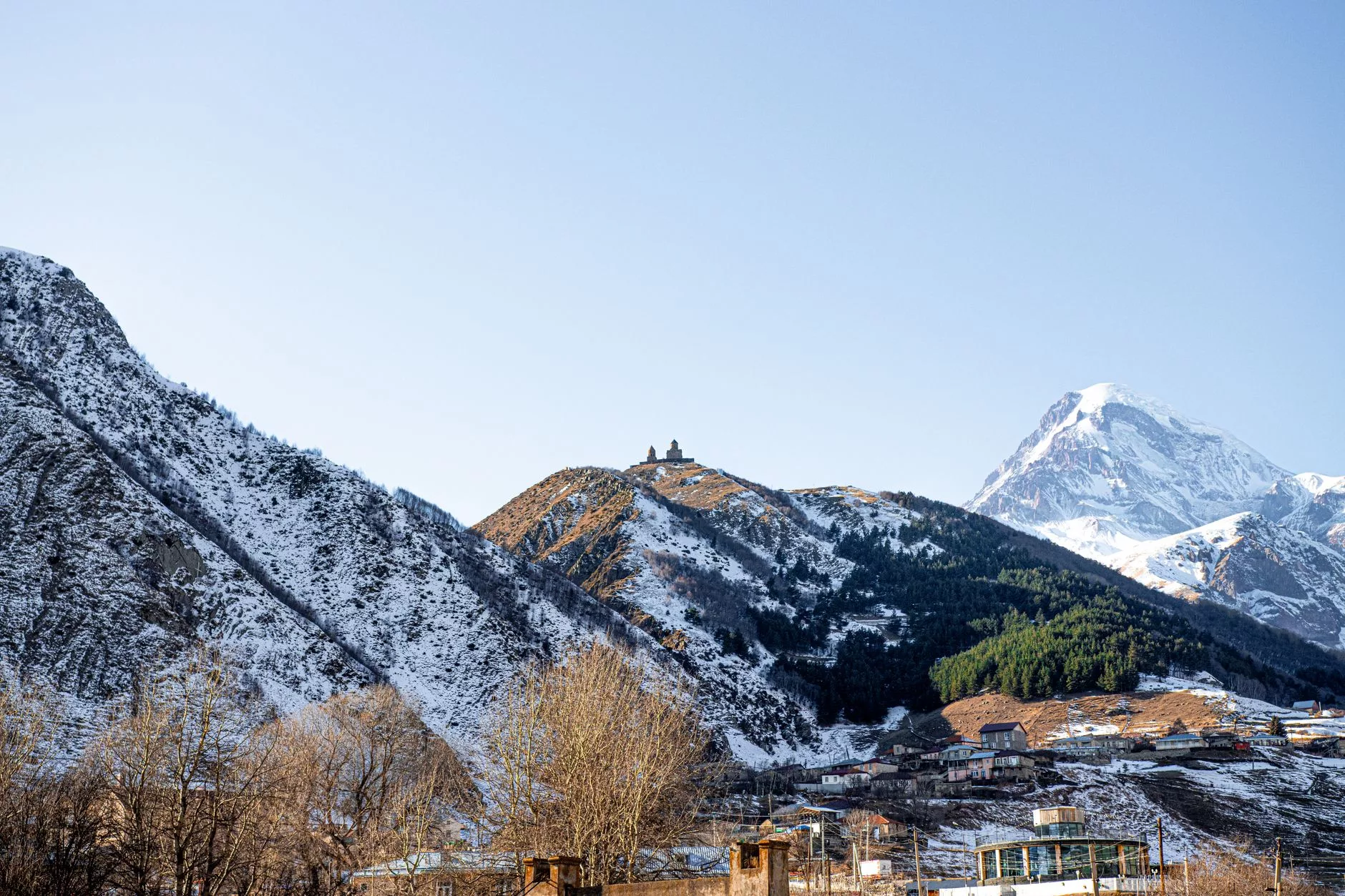 Gergeti Kilisesi arkasında karlı Kazbek dağları
