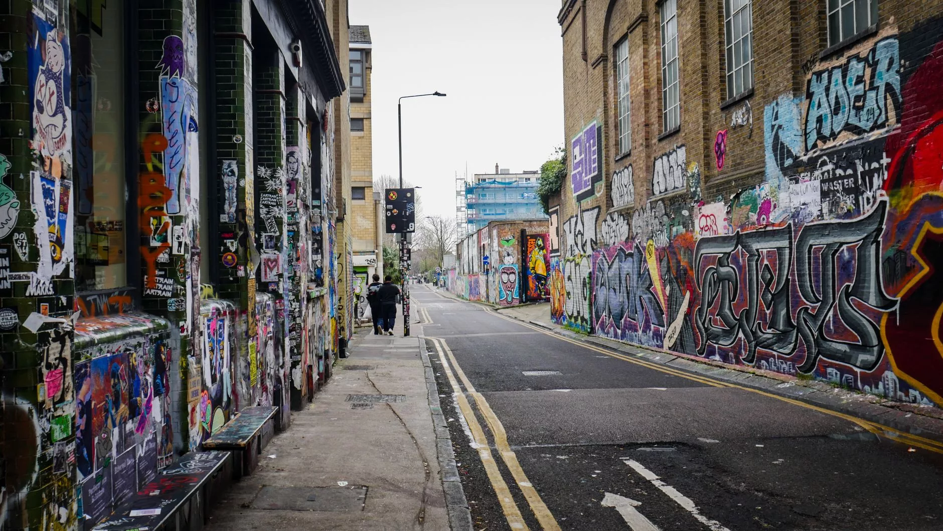 Londra – Brick Lane bölgesindeki renkli sokak sanatı ve yerel bir yemek tezgahı