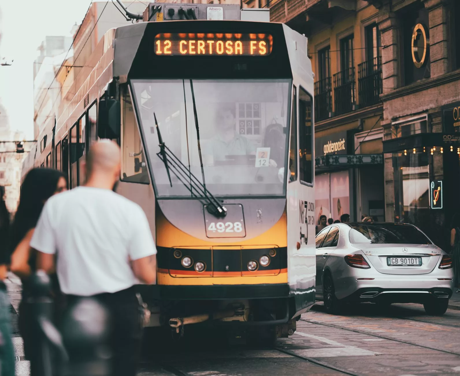 Milano metrosu içinde yolculuk yapan insanlar ve renkli hat tabelaları