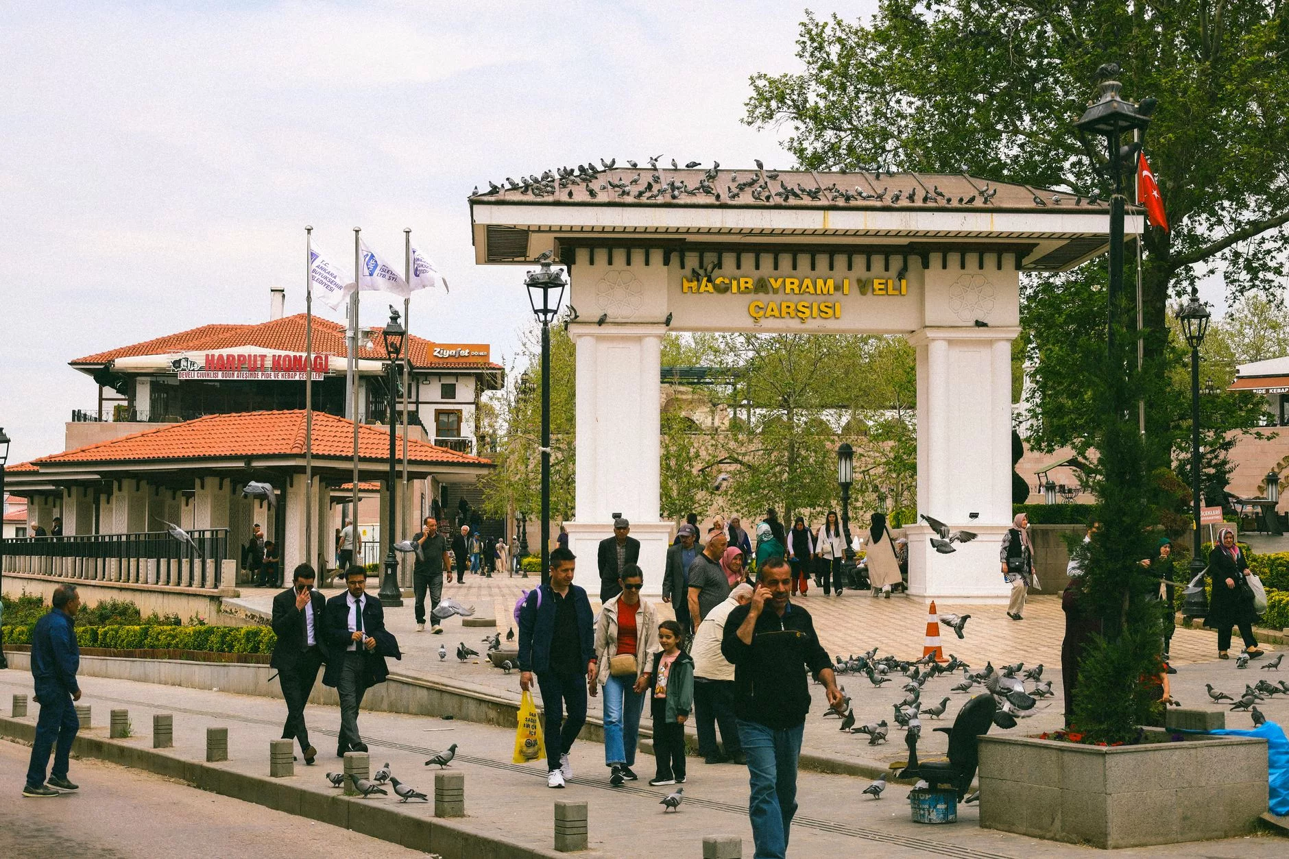 Başçarşı meydanındaki Sebil önünde güvercinlerle vakit geçiren insanlar