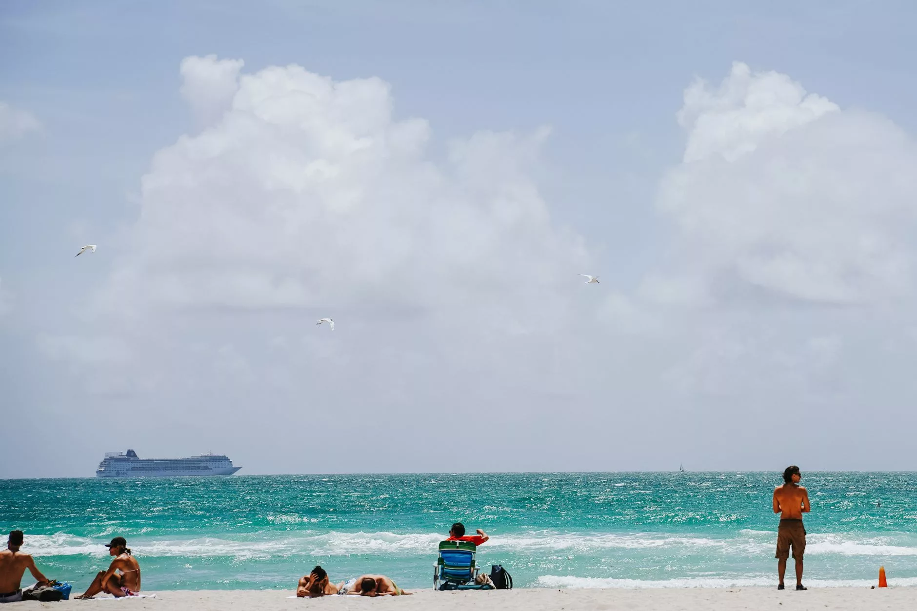Miami Beach sahilinde yürüyüş yapan turistler