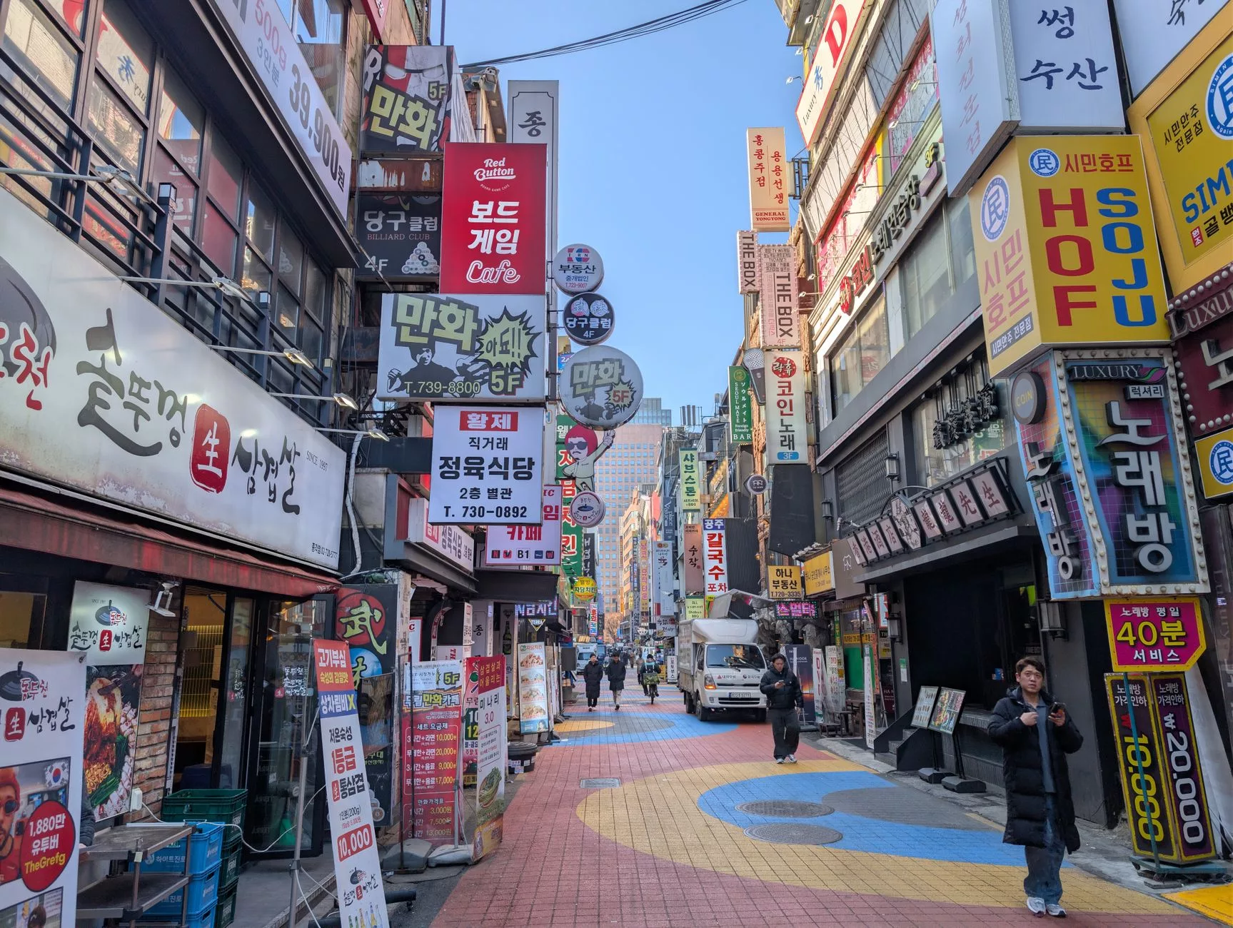 Seul Hongdae sokaklarında gece ışıkları altında yalnız yürüyen bir gezgin