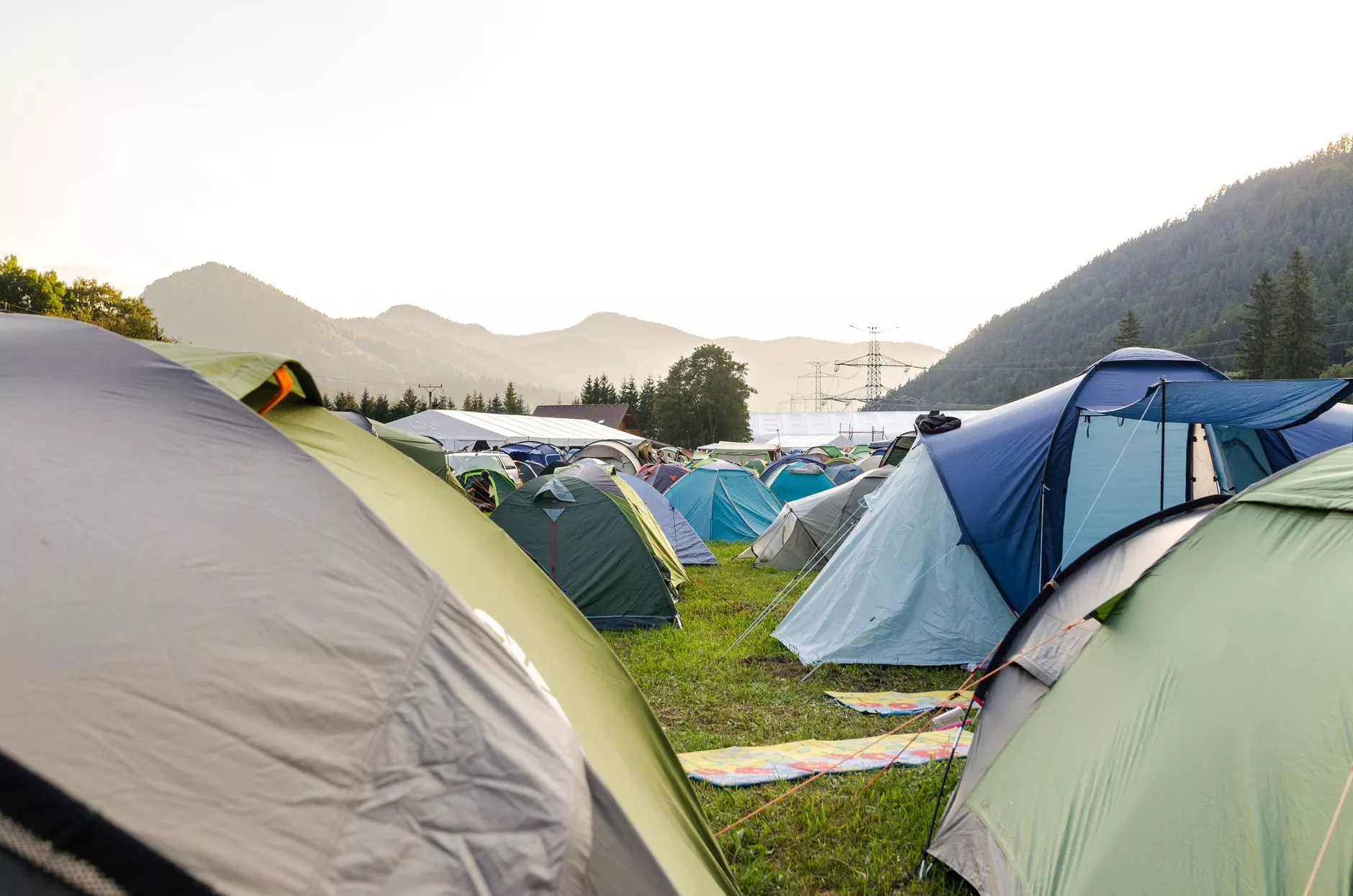 Festival alanında kamp çadırları ve sırt çantalı katılımcılar