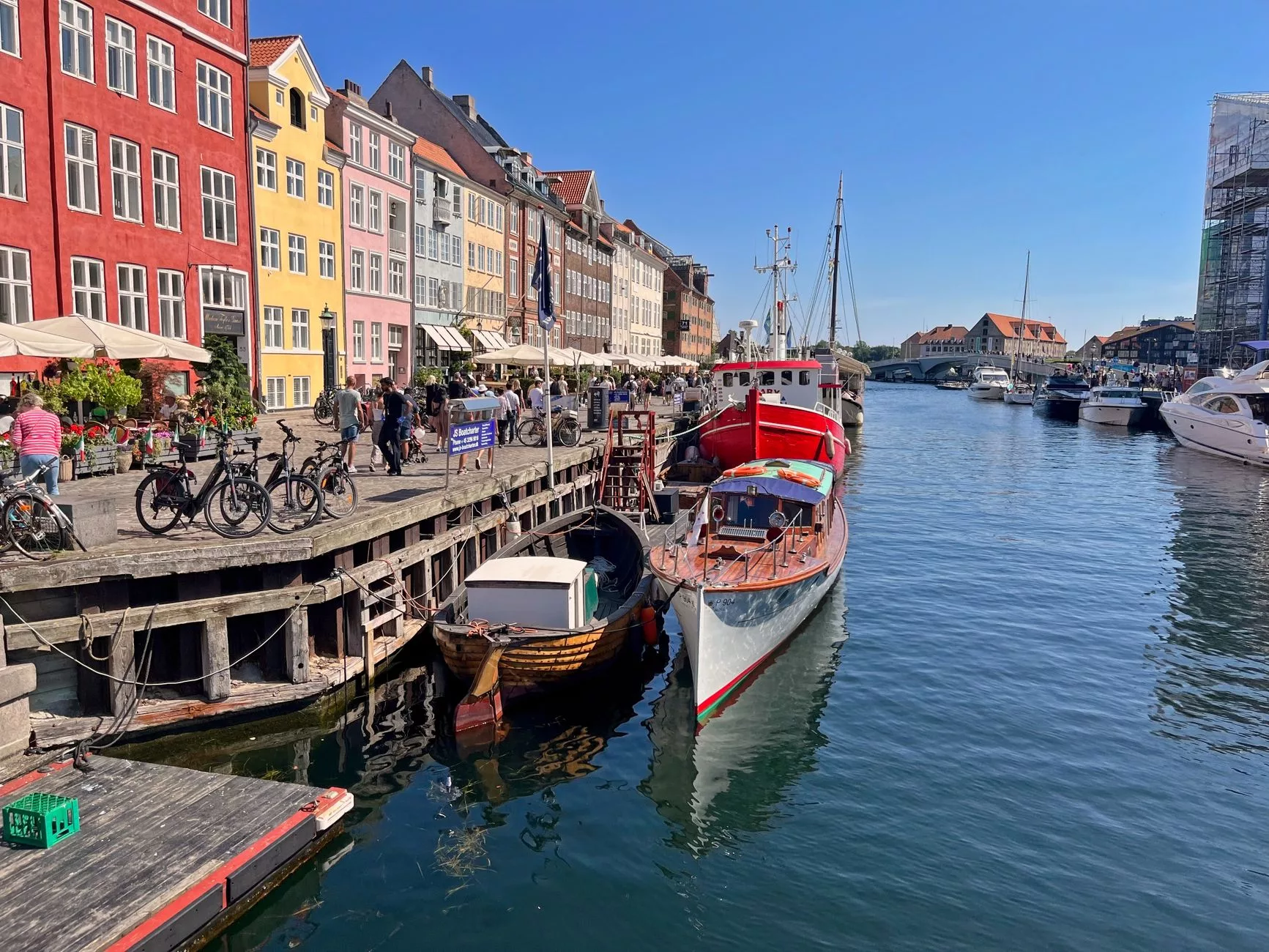 Kopenhag Nyhavn kanalı kenarında bisikletiyle duran solo seyahatçi