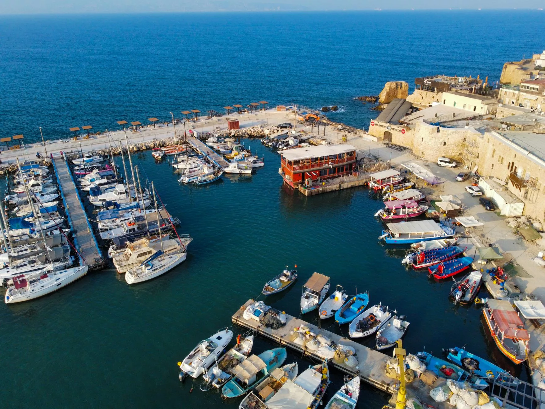 Girit Heraklion limanında demirlemiş geleneksel balıkçı tekneleri ve arka planda Venedik kalesi