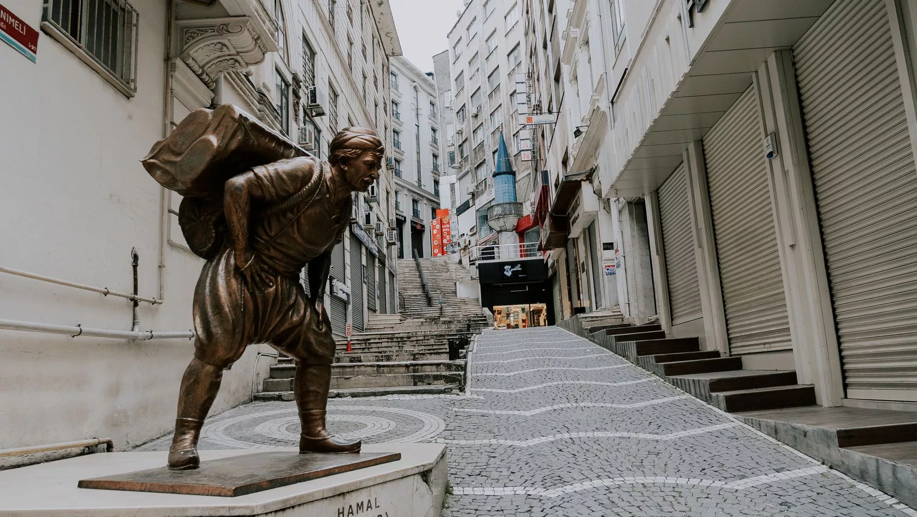Şehrin merkezinden uzak, ıssız bir sokakta valizle bekleyen bir gezgin