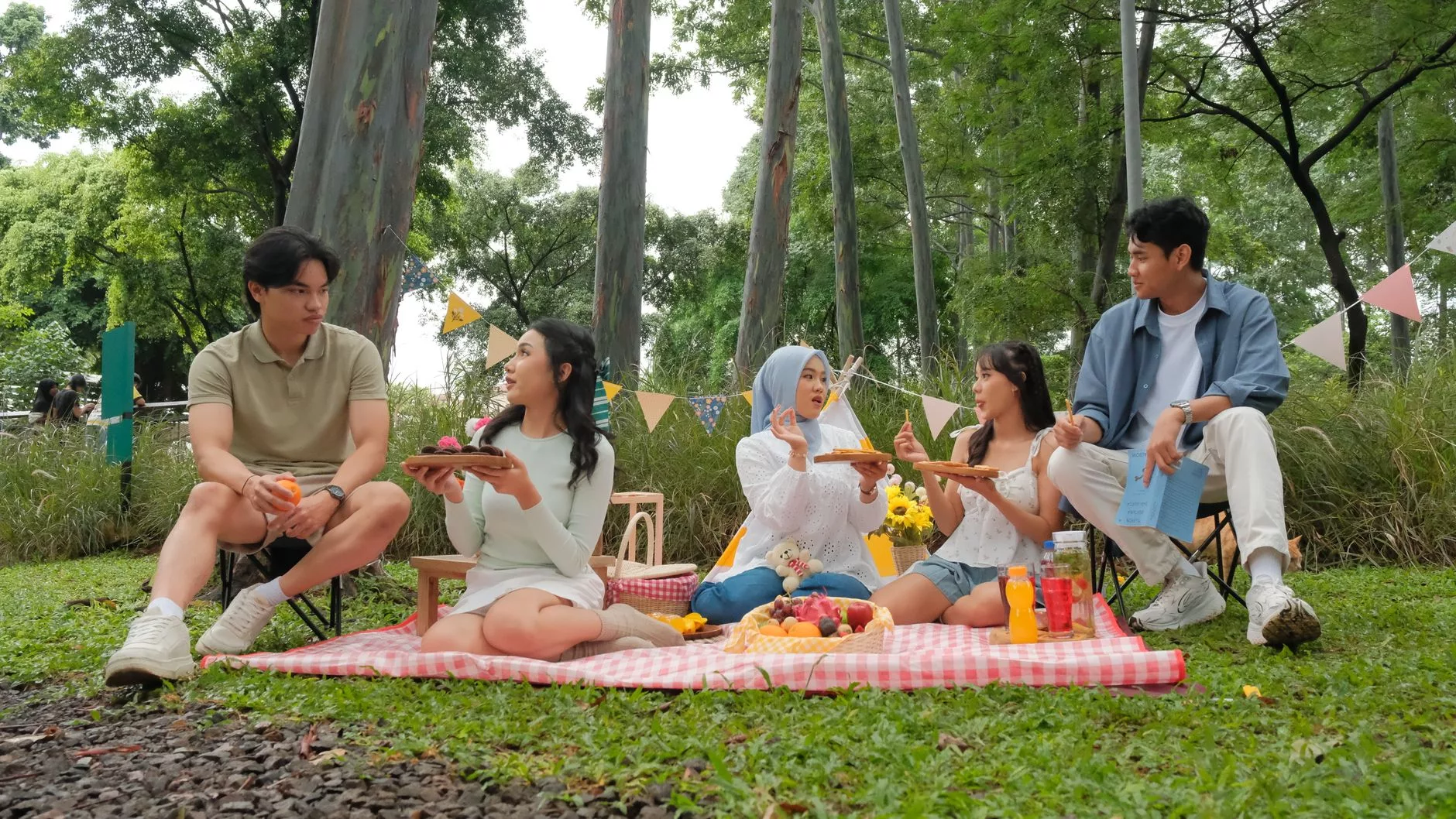 Aile bireylerinin bir parkta piknik yaparken çekilmiş fotoğrafı