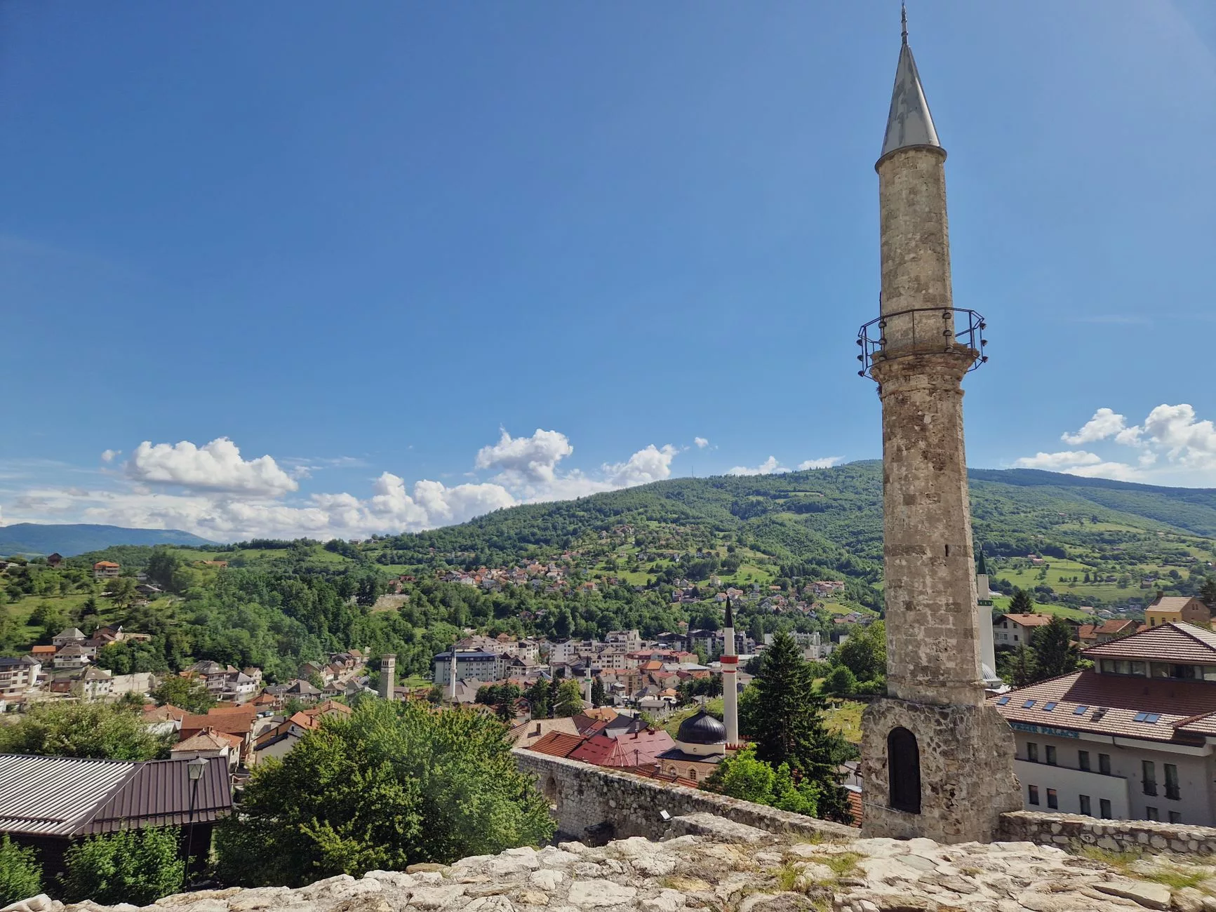 Başçarşı'da sebilin önünden geçen gezginler ve arka planda tarihi cami minareleri