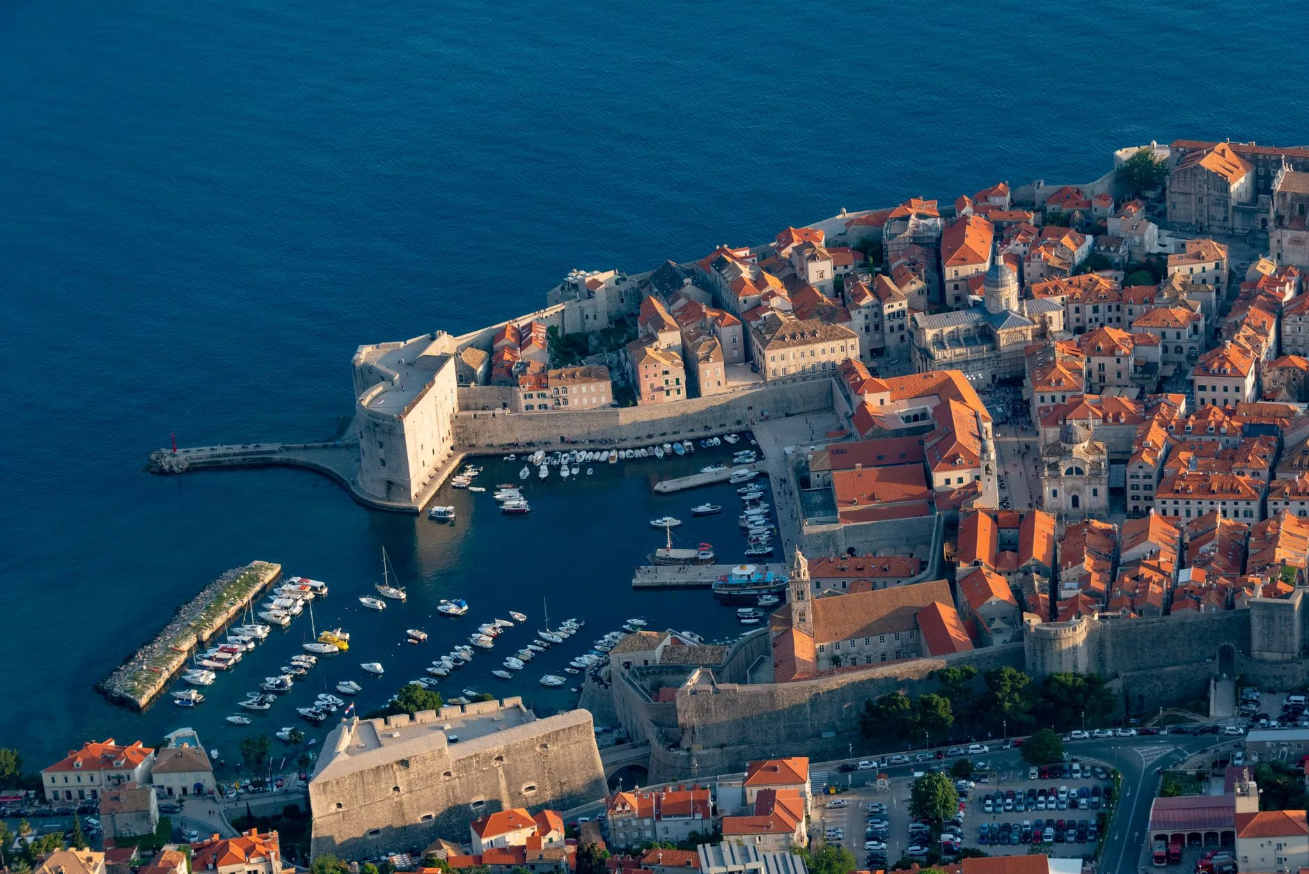Dubrovnik Havalimanı dış hatlar çıkışında bekleyen shuttle otobüsleri ve tarihi surların uzaktan görüntüsü