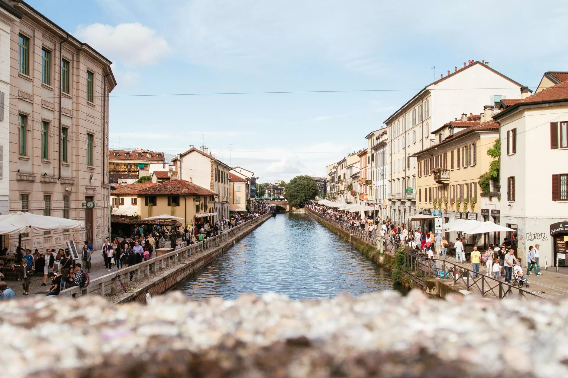 Navigli kanal kıyısında aperitivo masaları ve açık büfe stantları