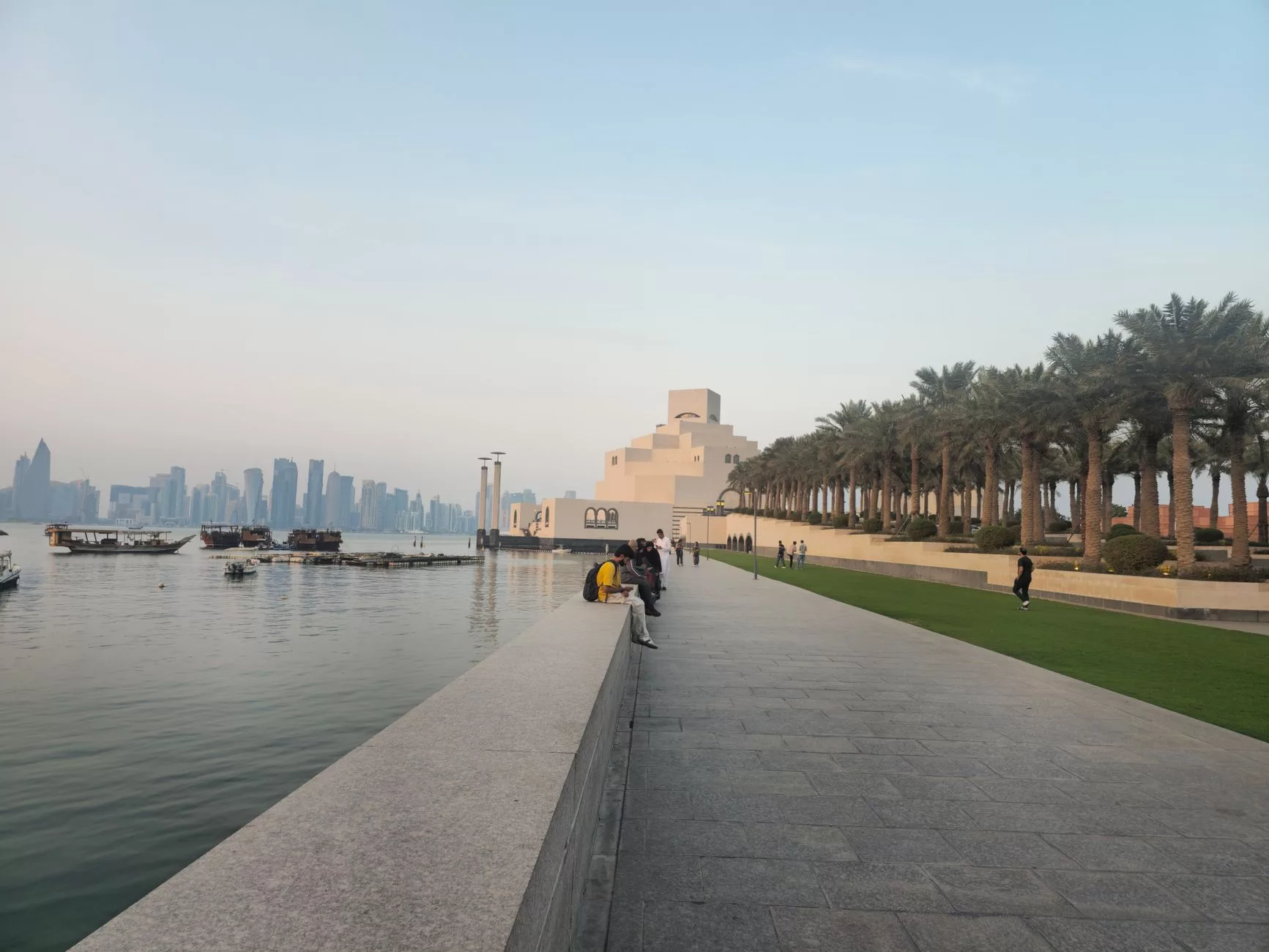 Doha Corniche sahil şeridinde akşam yürüyüşü yapan gezginler