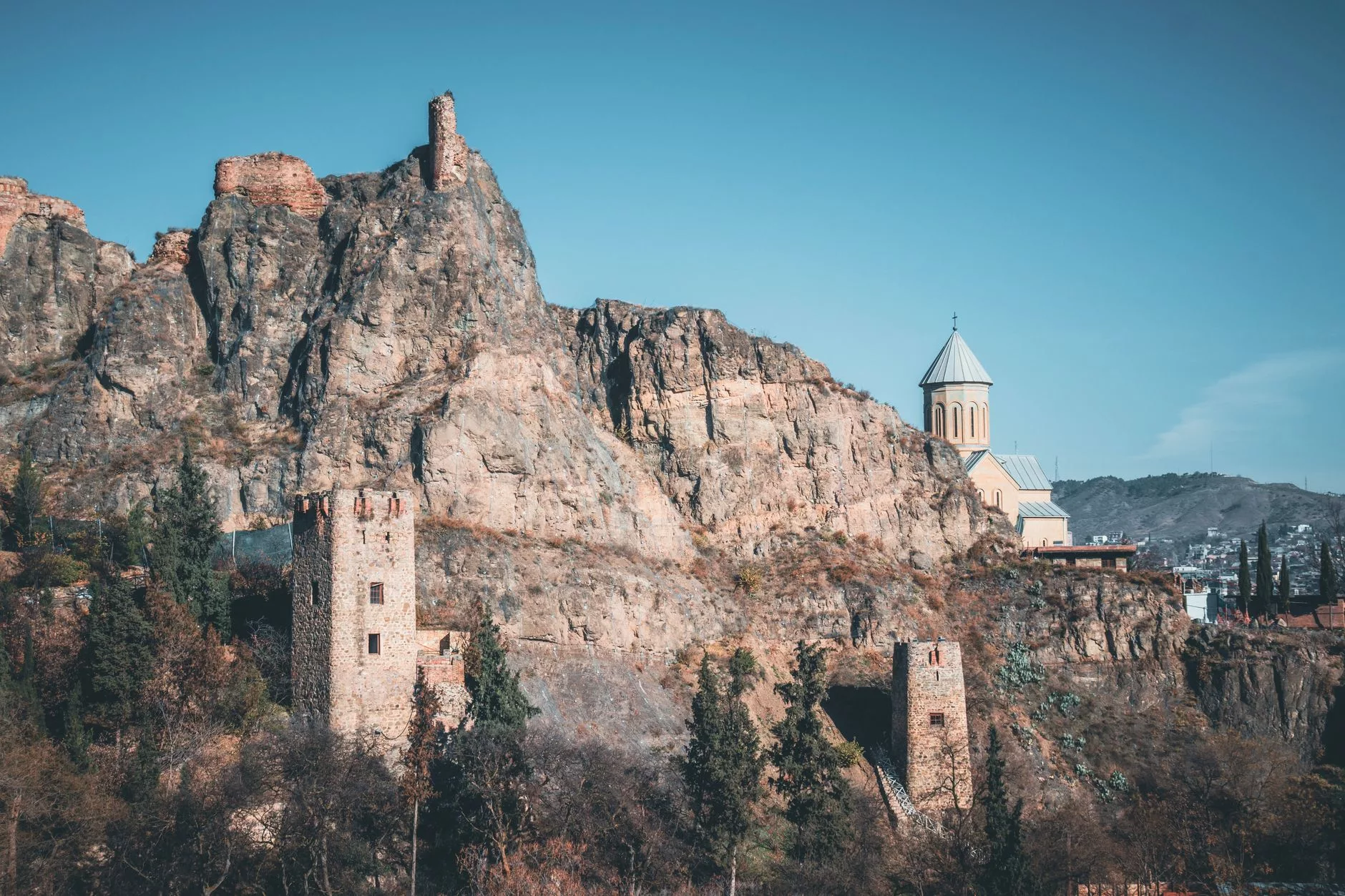 Tiflis semalarında süzülen uçak ve arka planda Narikala Kalesi