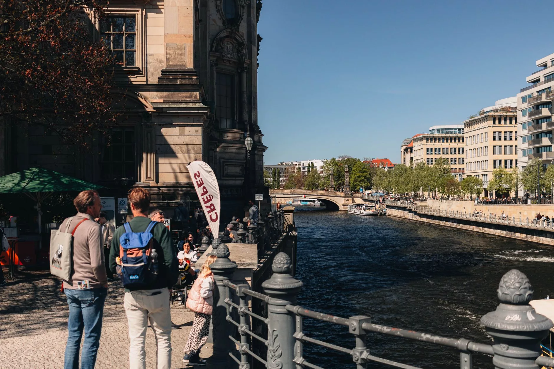 Berlin müze adasında nehir kenarında yürüyen gezginler