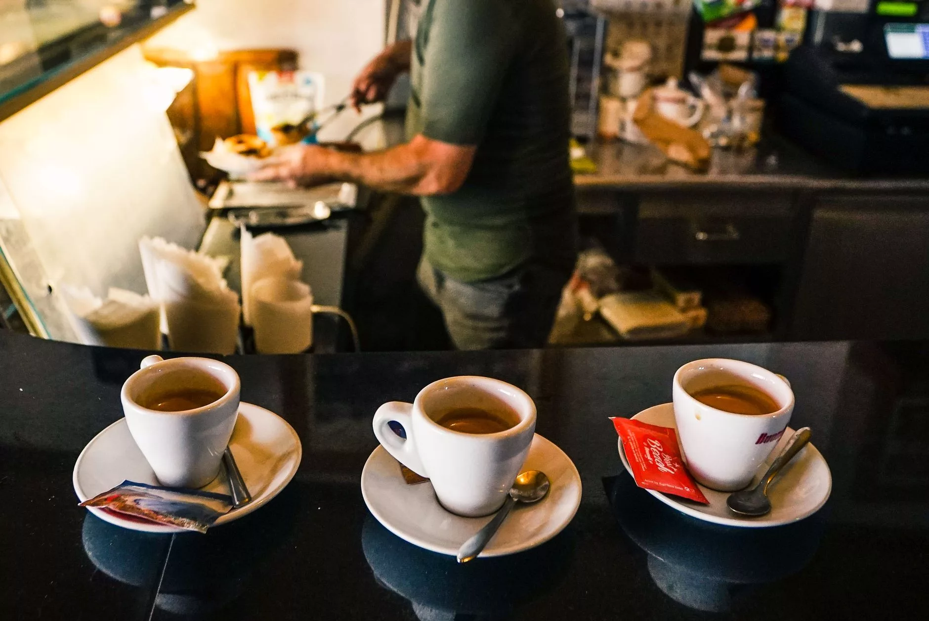 Bir İtalyan kafesinde ayakta espresso içen yerel halk ve bar tezgahı detayları