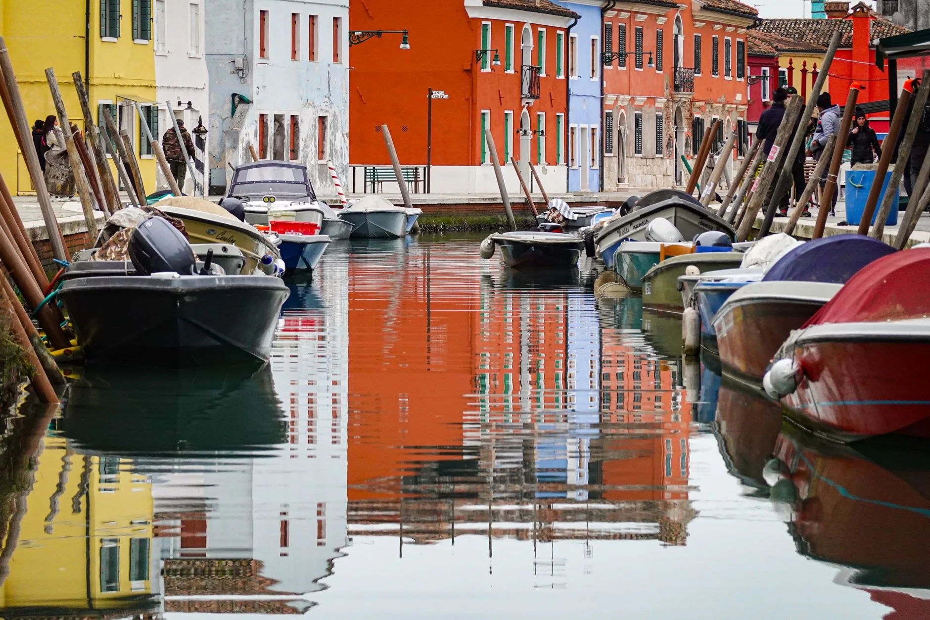 Burano adasındaki renkli evlerin kanal kenarı yansımaları