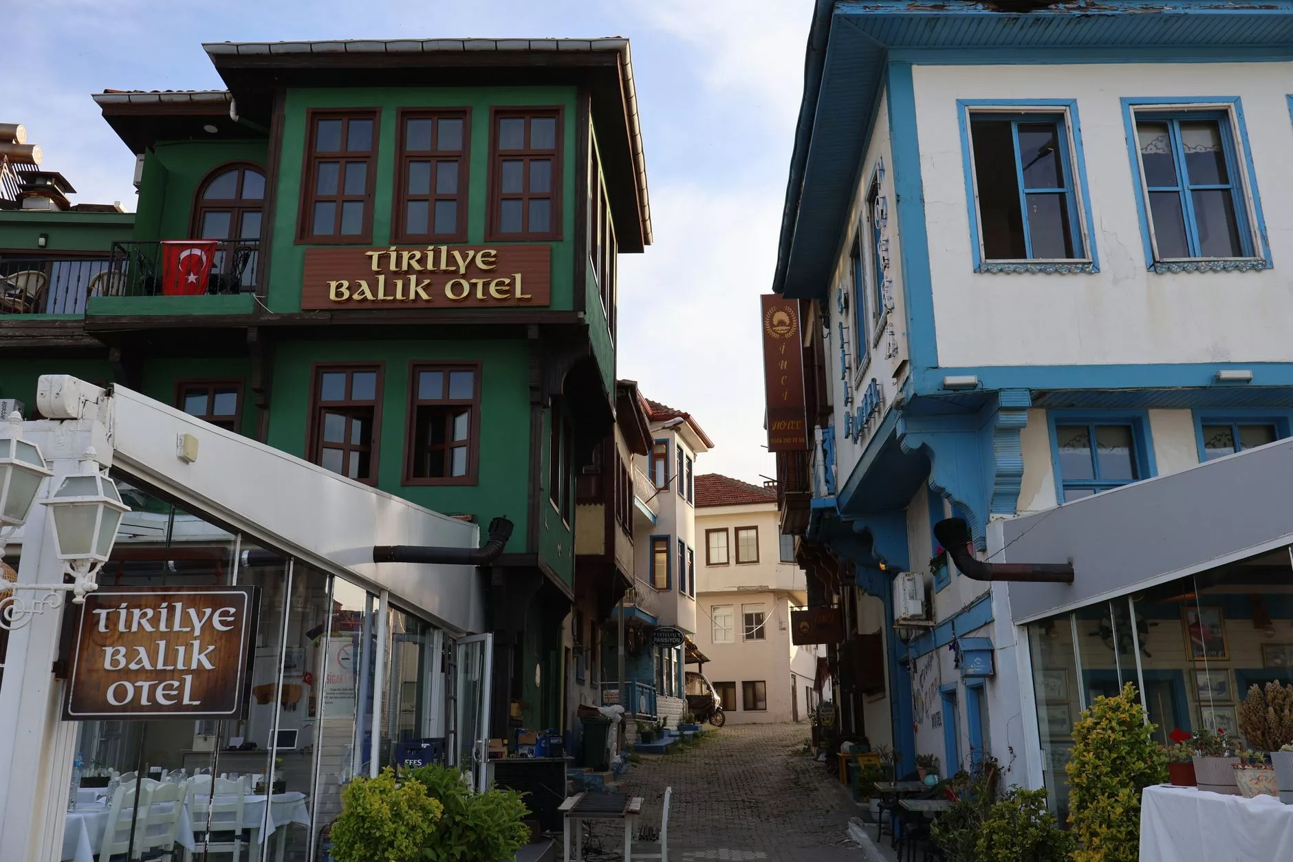 Akıllı telefon ekranında farklı ülkelerin konumlarından otel fiyatlarını karşılaştıran bir gezgin