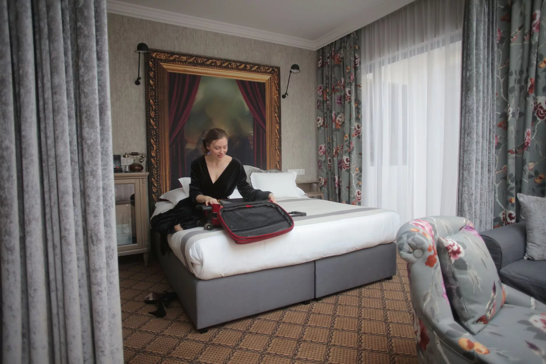 Modern bir otel odasında valizini açan bir gezgin