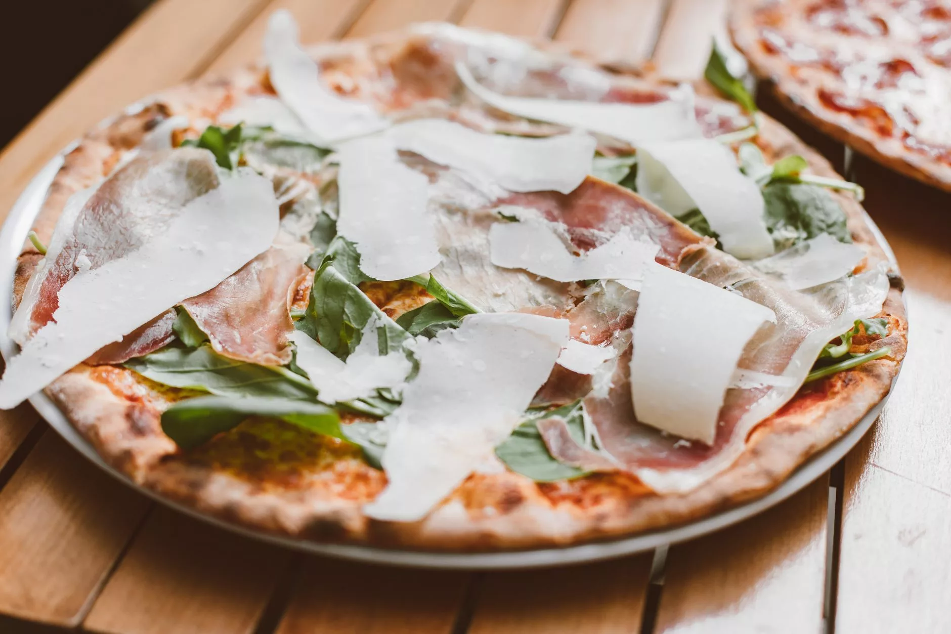 Roma'nın yerel bir fırınında taze çıkmış, dilimlenmiş ve çeşitli malzemeli pizza al taglio çeşitleri
