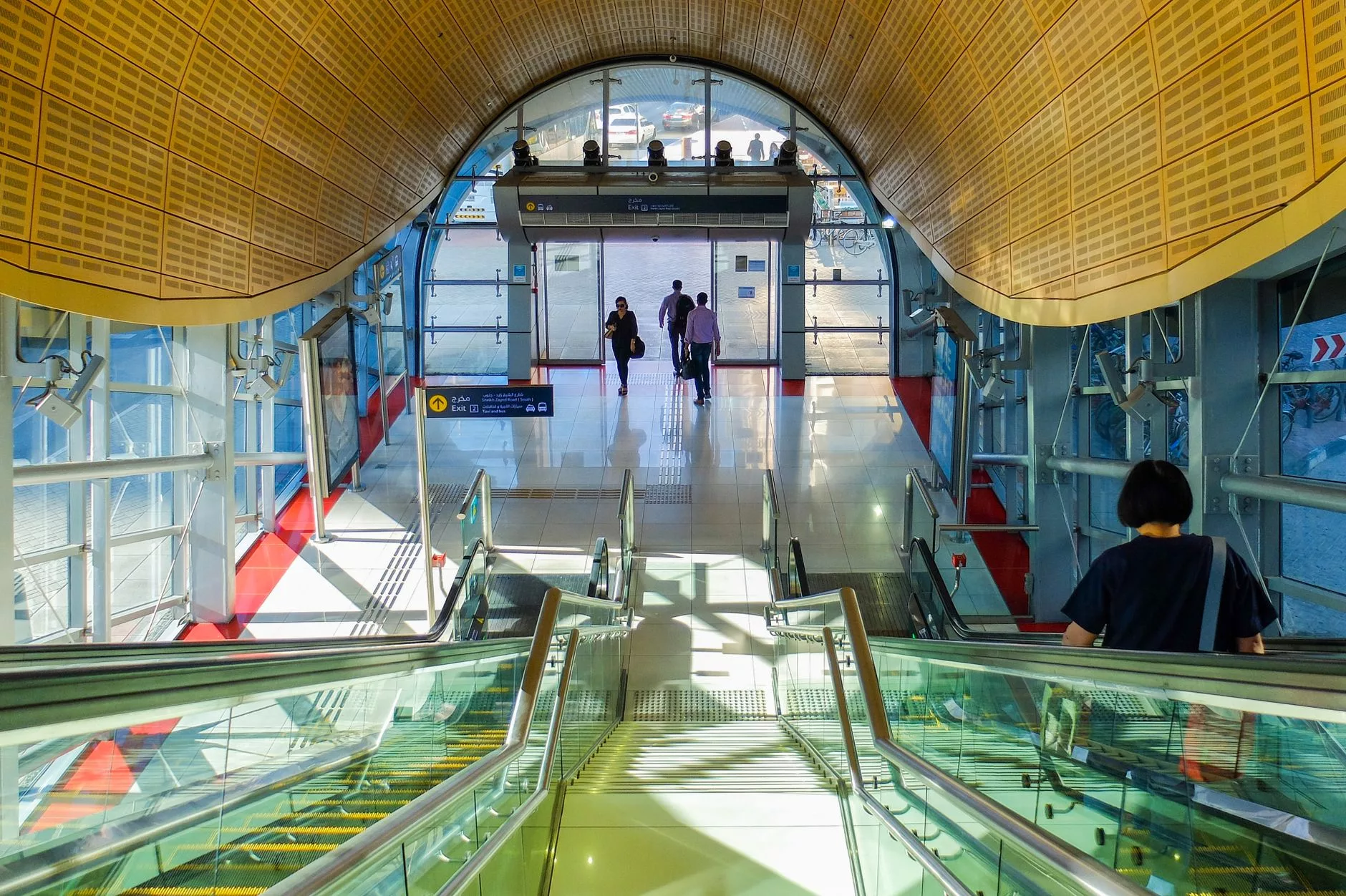 Dubai de metro istasyonu içinde modern giyimli yolcular ve tabela