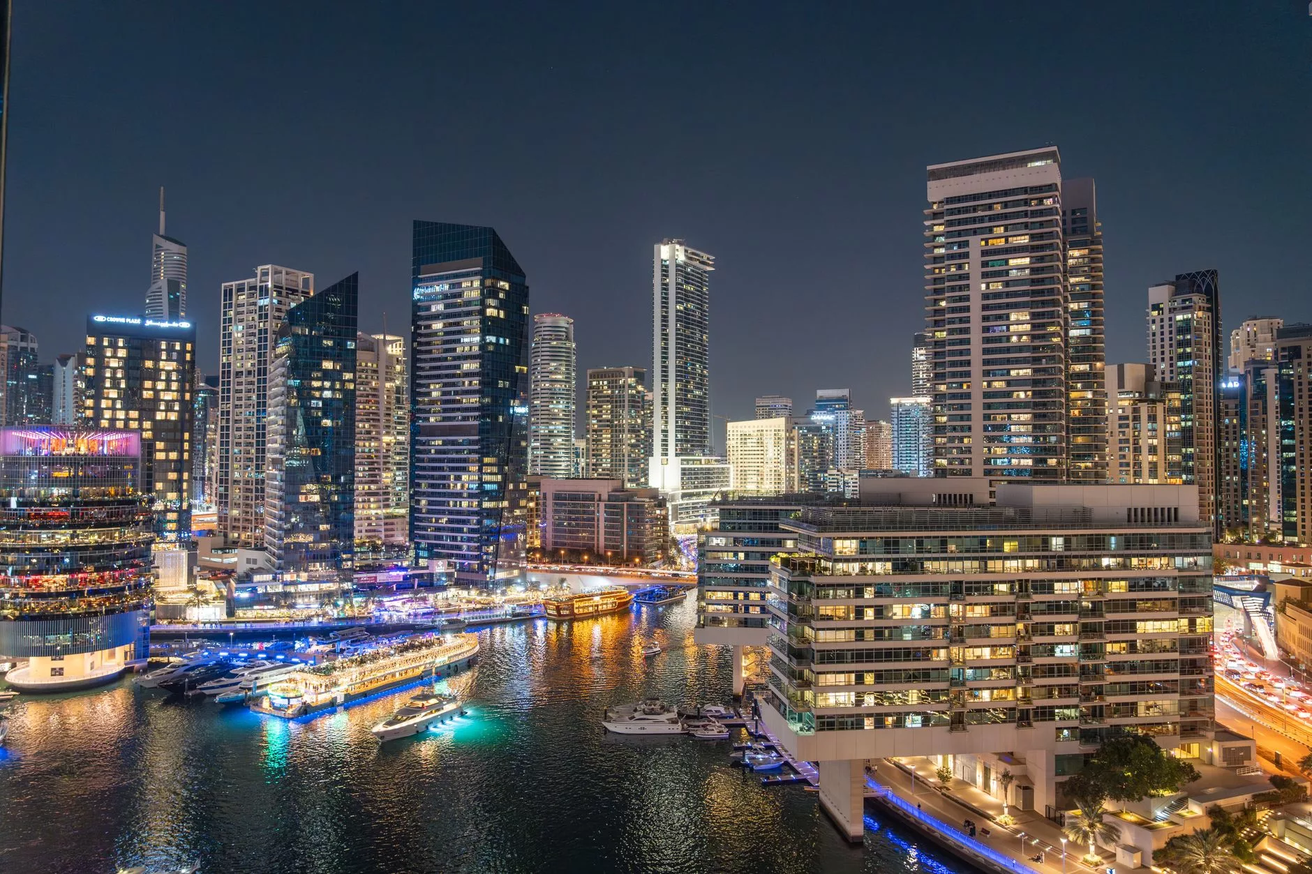 Dubai Marina sahilinde akşam yürüyüşü yapan insanlar ve ışıklar