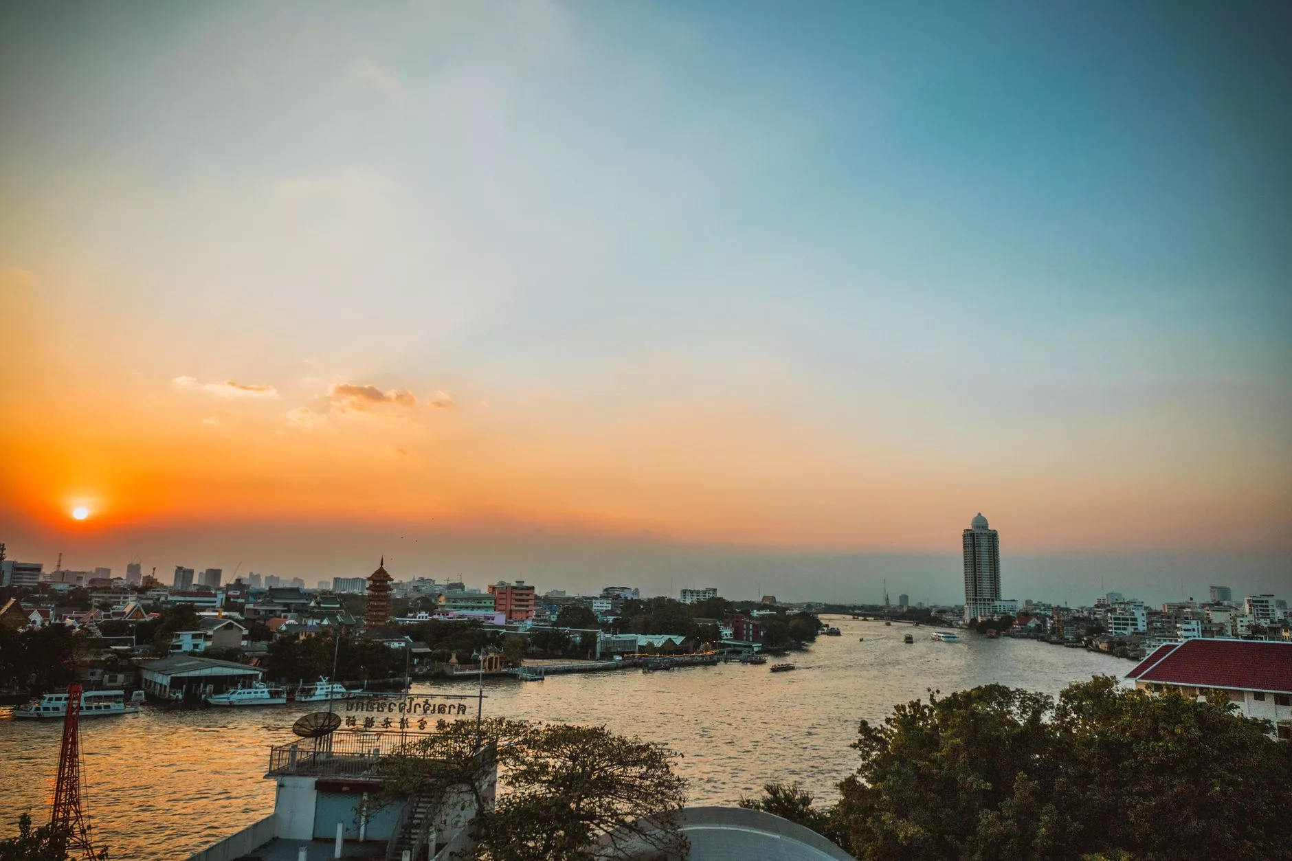 Bangkok Chao Phraya Nehri üzerinde gün batımı ve yüzen tekneler