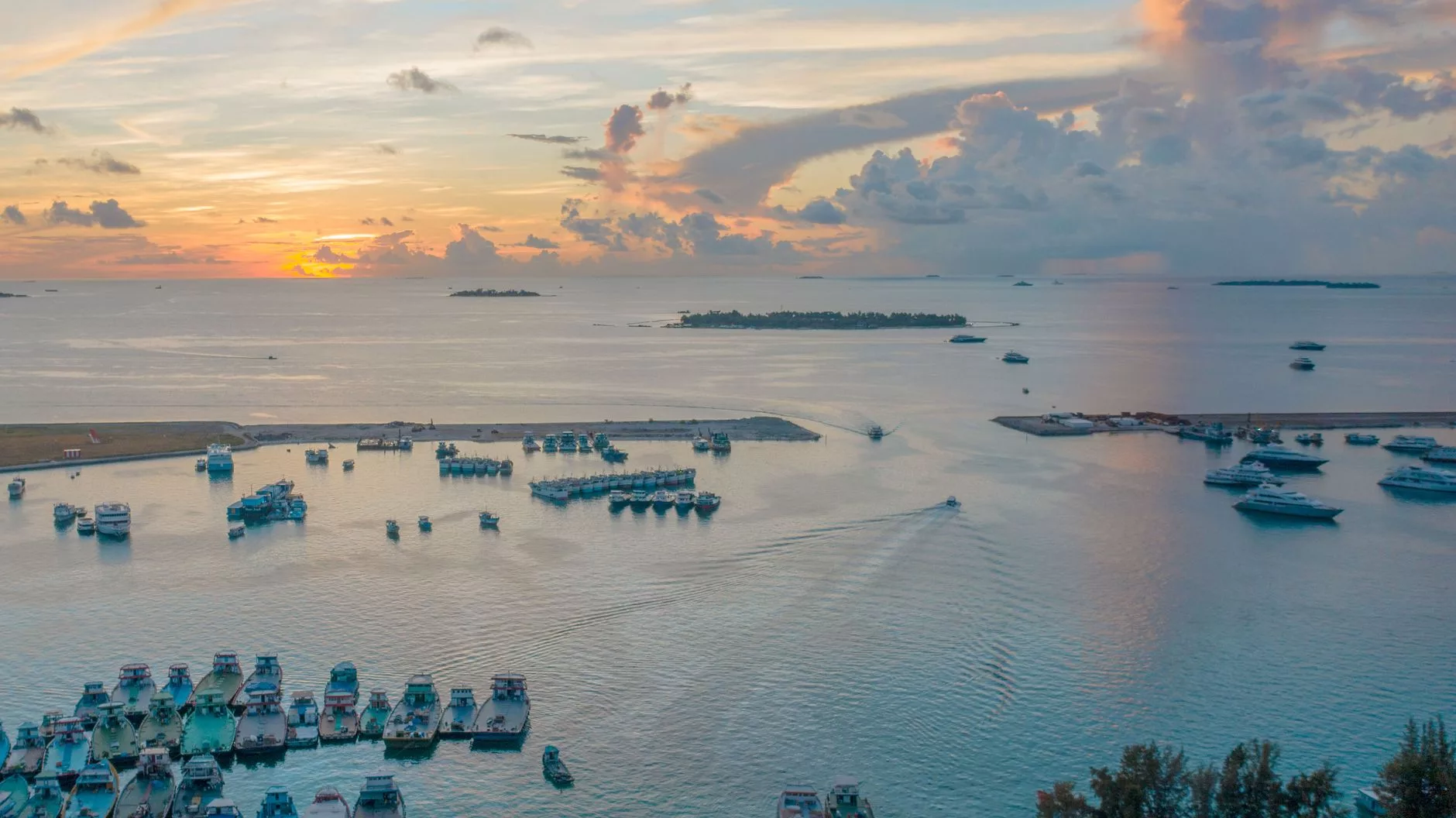 Maldivler Hulhumale sahilinde geleneksel balıkçı tekneleri ve gün batımı