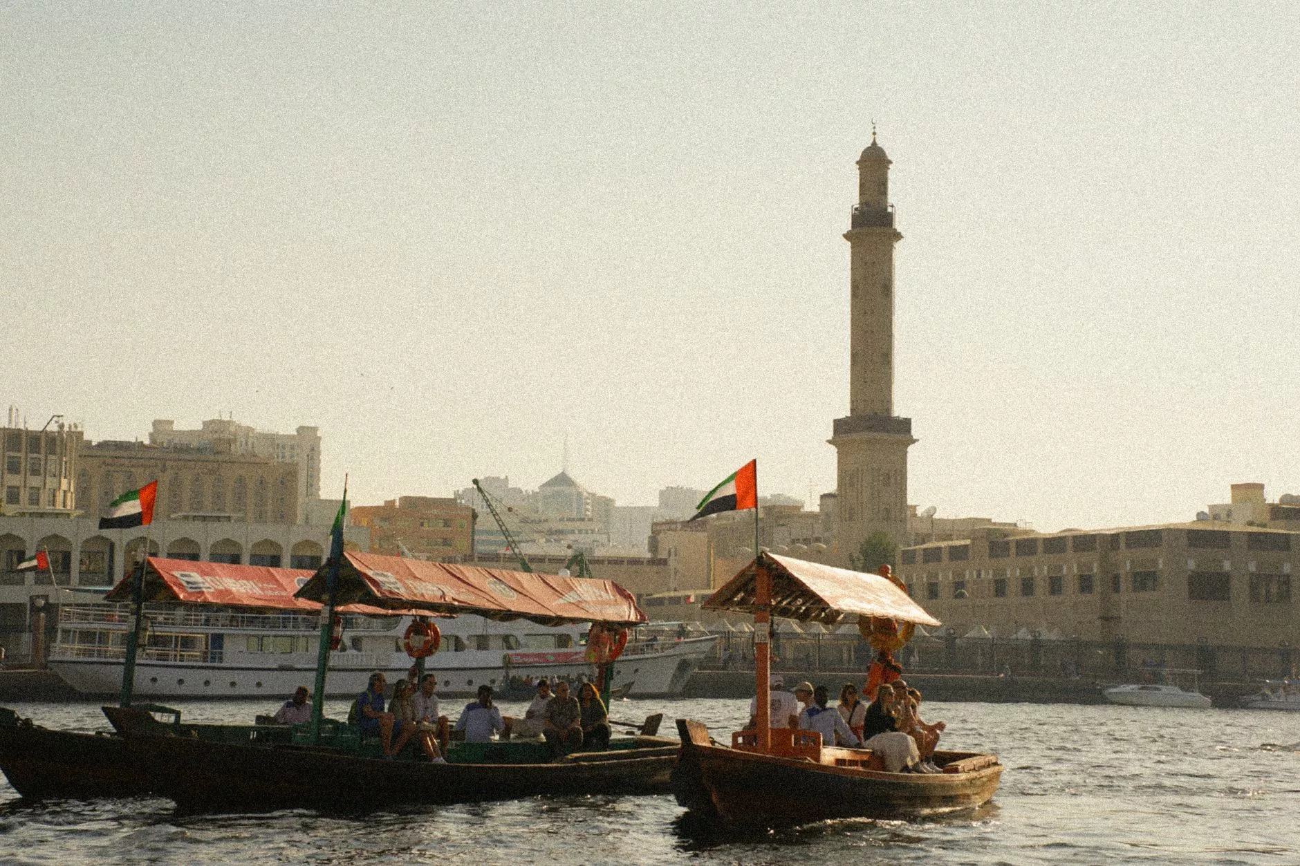 Dubai Creek üzerinde geleneksel ahşap abra tekneleri ve eski şehir manzarası