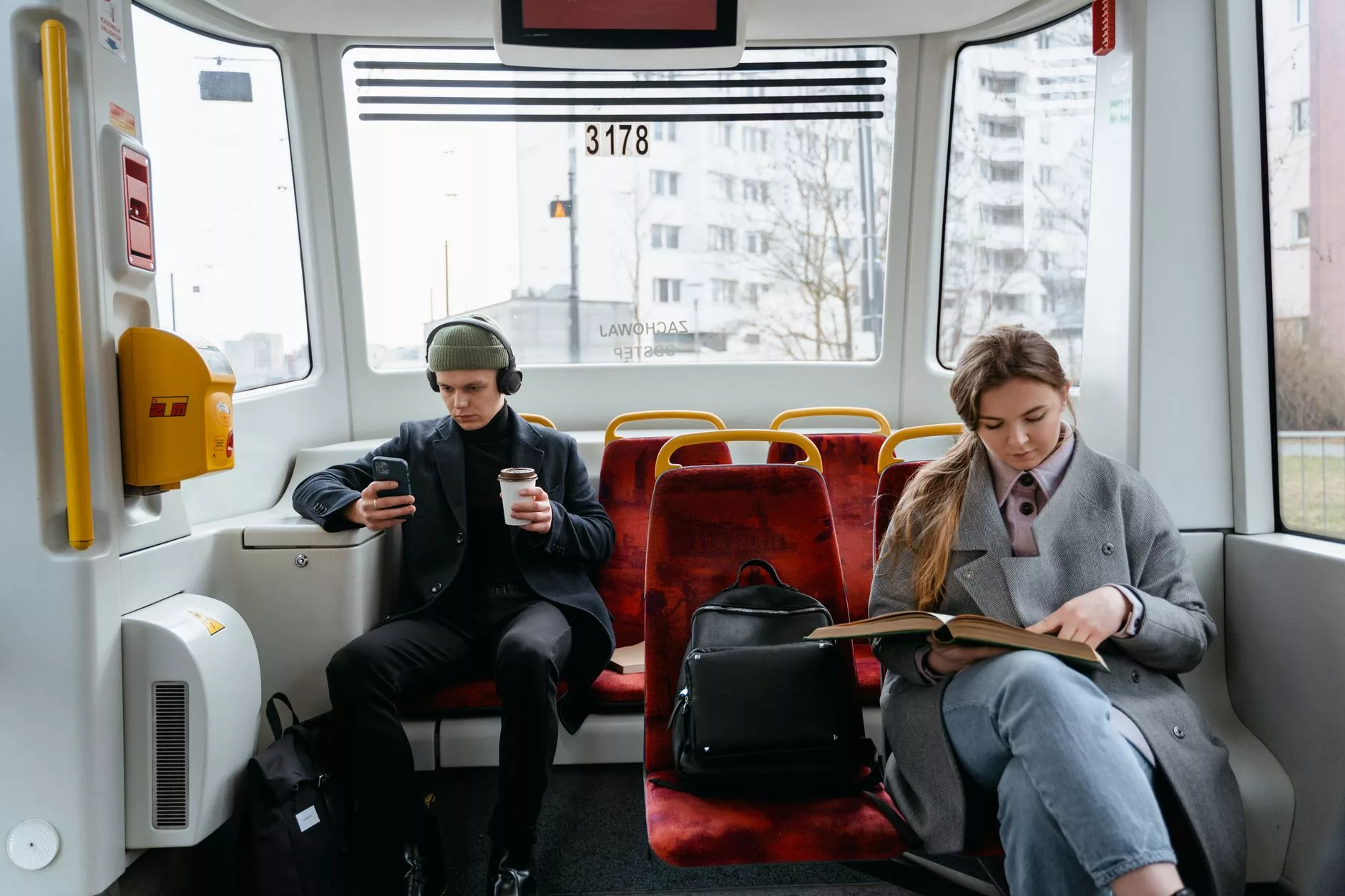 Karşılıklı oturulan tren koltuklarında kahve içen insanlar