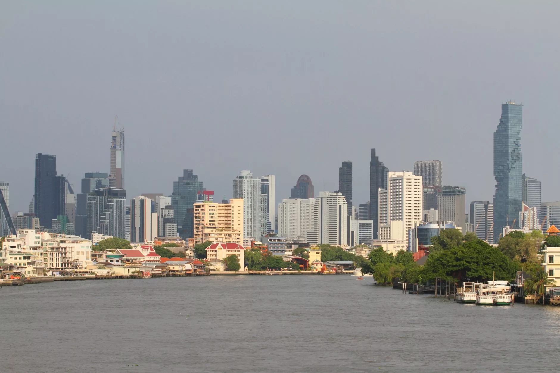 Bangkok Chao Phraya nehri üzerinde gün batımı ve modern silüet