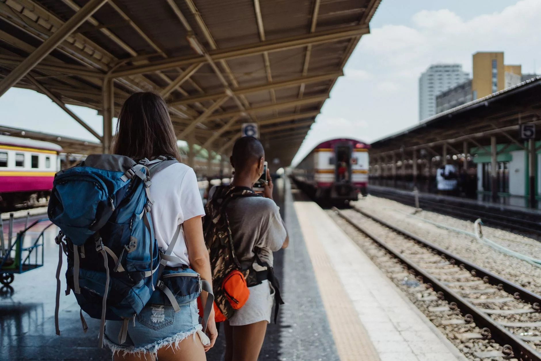 Tren istasyonunda elinde haritayla şaşkın bakan bir sırt çantalı gezgin