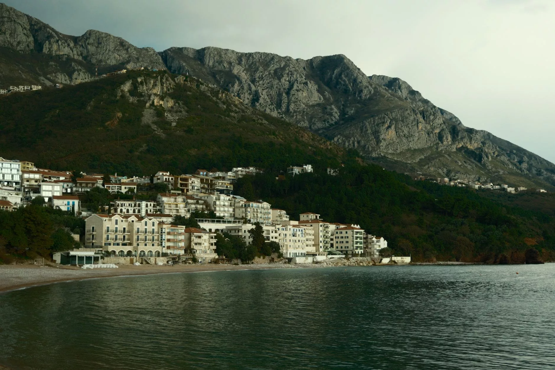 Kotor Körfezi üzerindeki dağların arasından süzülen bir yolcu uçağı