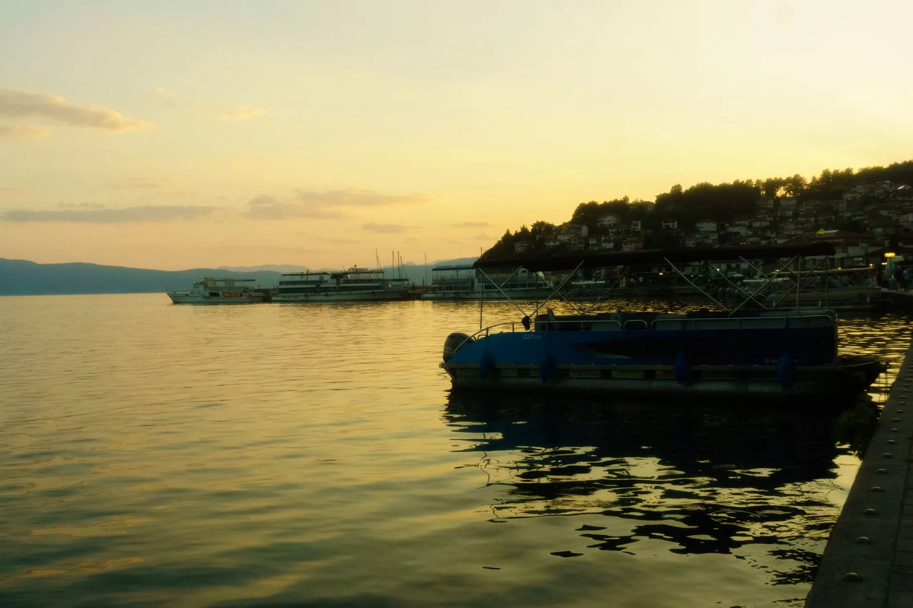 Ohrid Gölü kıyısında gün batımı ve yelkenliler