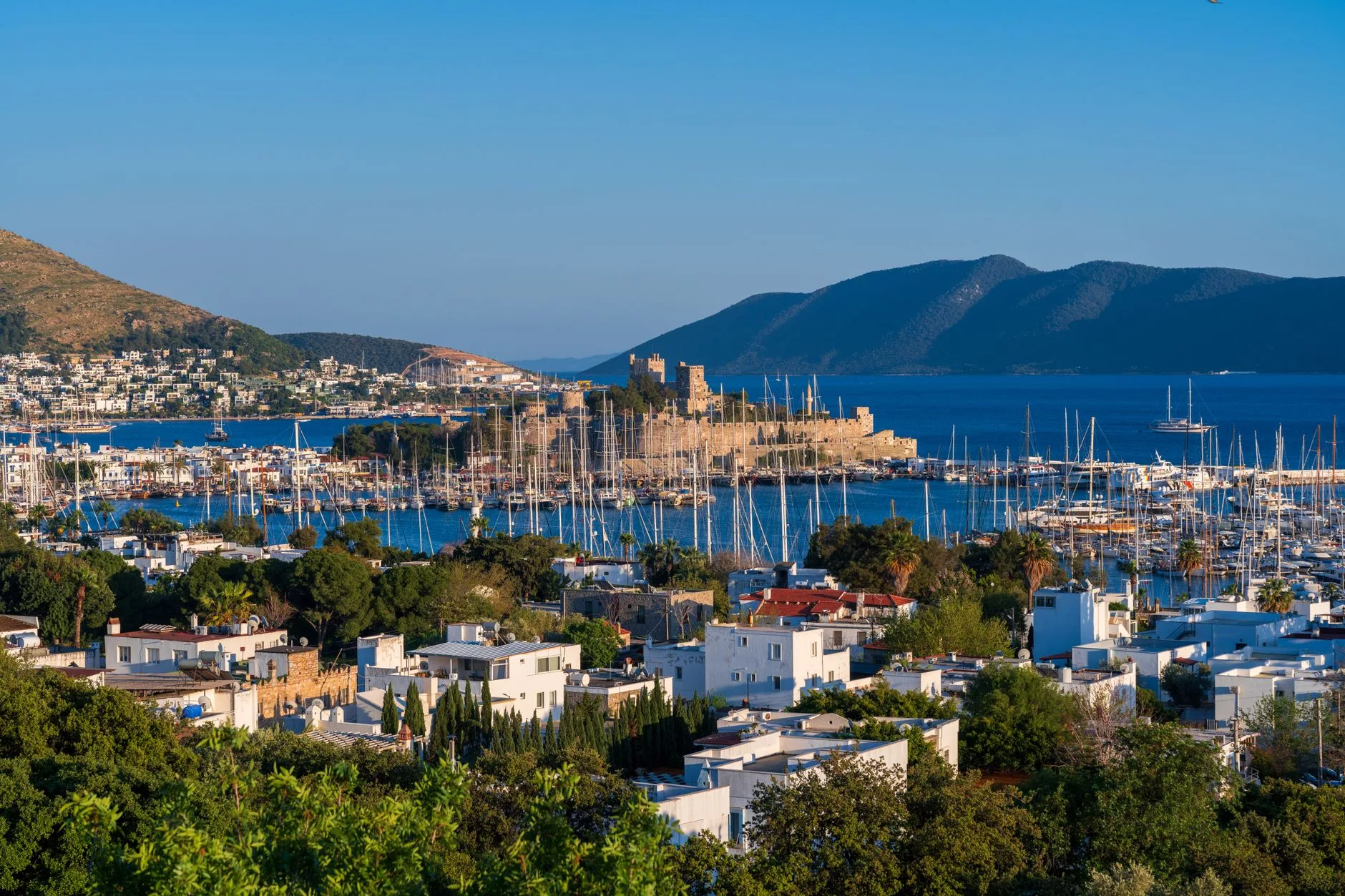 Milas Bodrum Havalimanı dış hatlar terminali önünde inen yolcular ve mavi servis otobüsleri