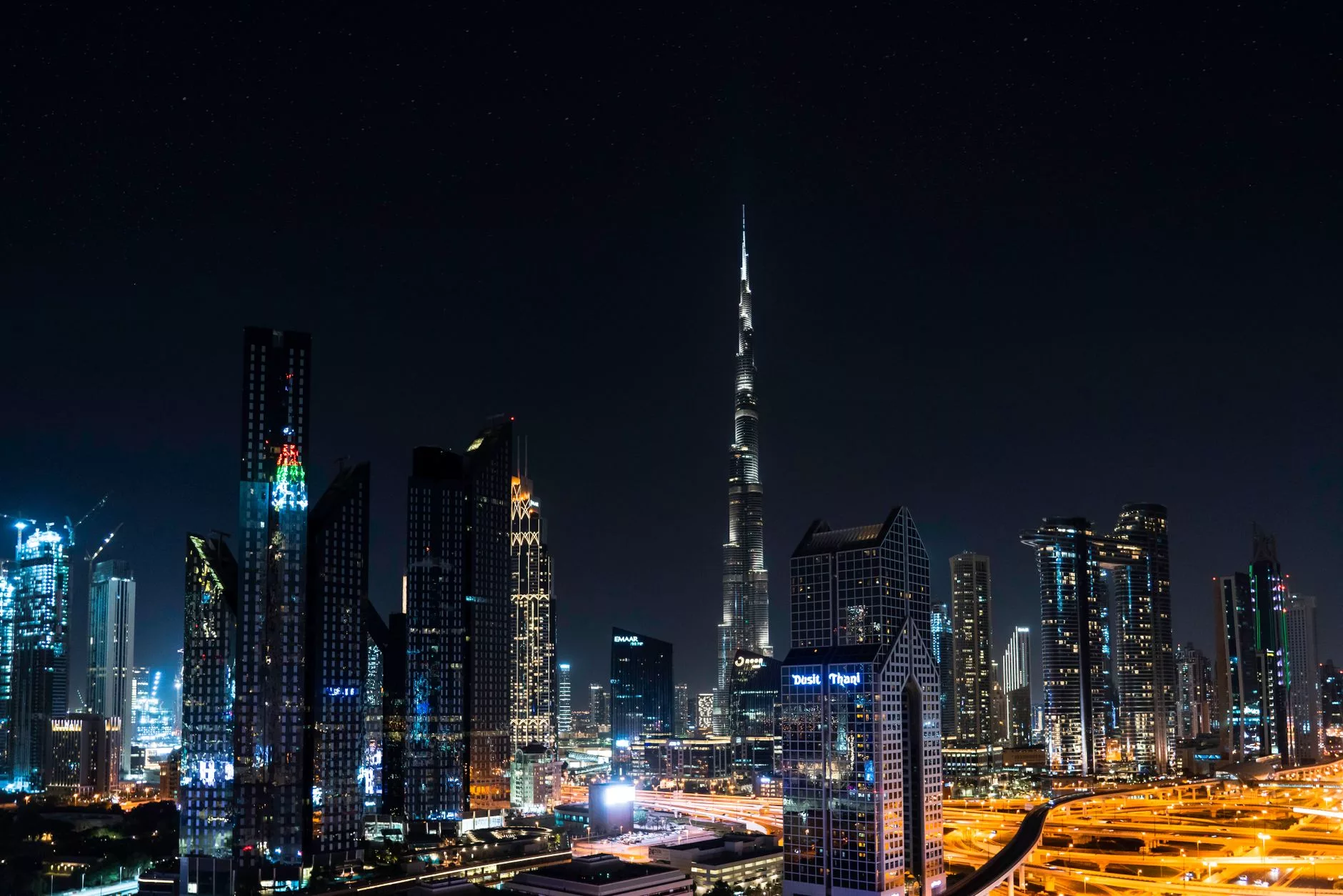 Dubai semalarında süzülen bir yolcu uçağı ve arkada parlayan Burj Khalifa