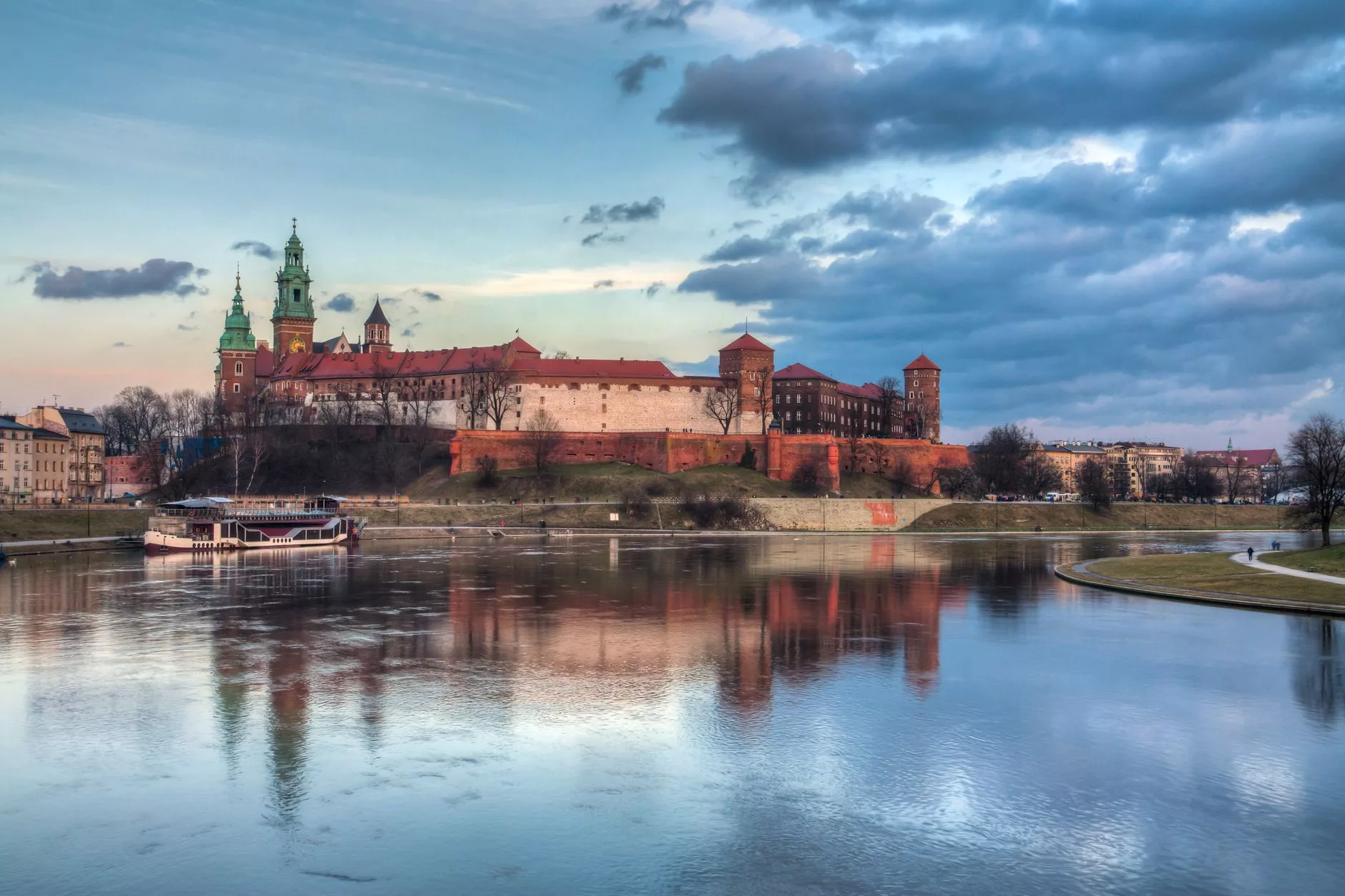 Wawel Kulesi'nden Vistül Nehri'ne bakan turuncu gün batımı manzarası