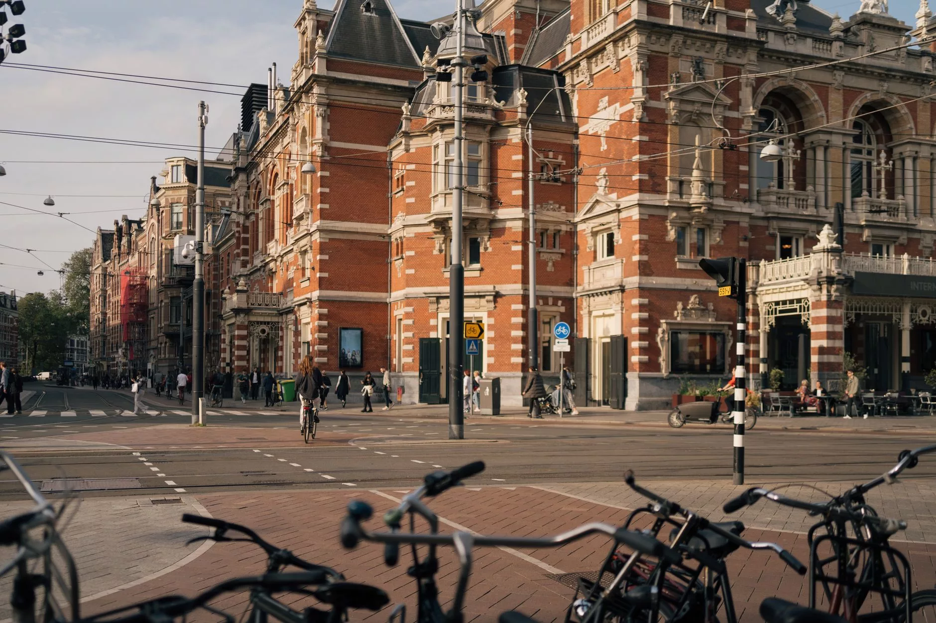 Amsterdam tarihi mimari binaları ve önünde duran turuncu kilitli bisikletler