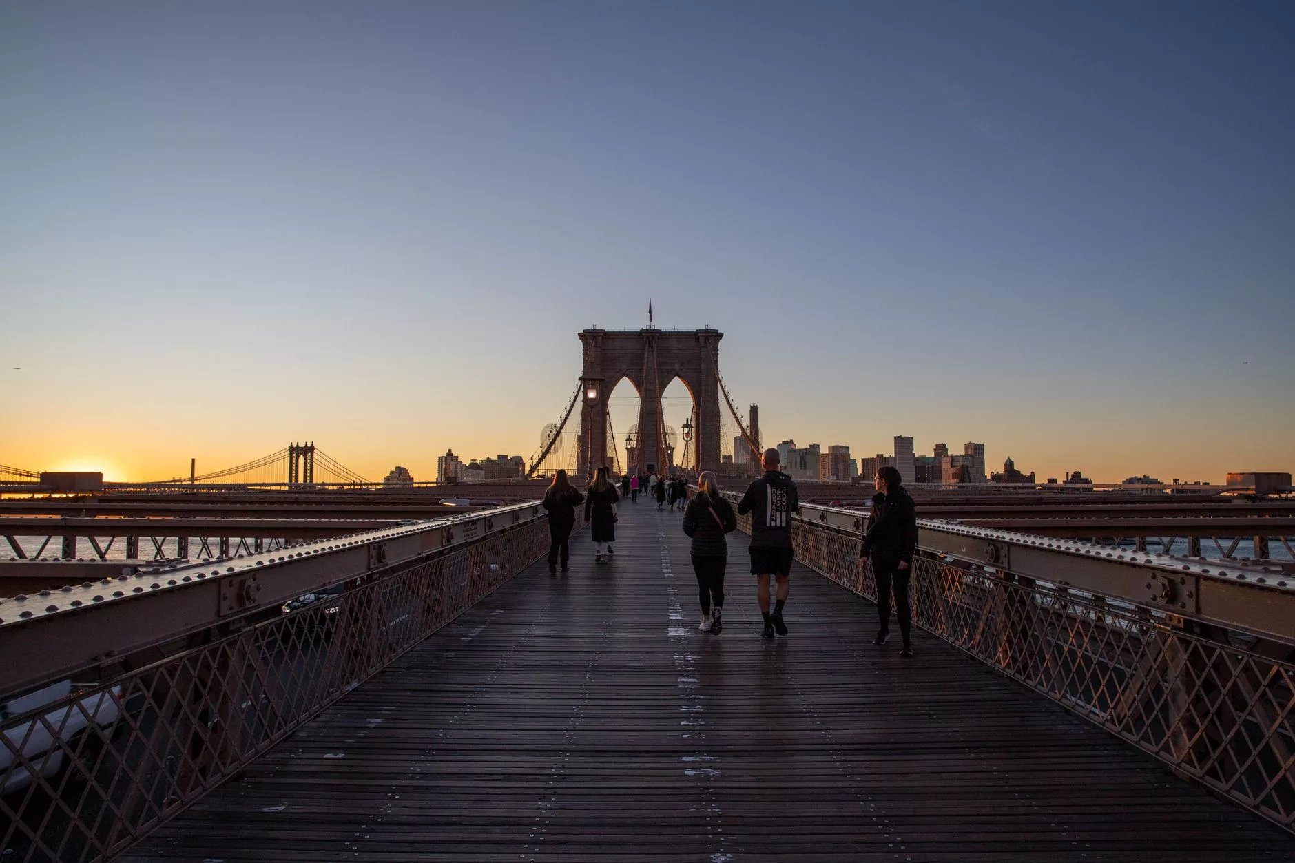 New York + Brooklyn Bridge pedestrian walkway sunset