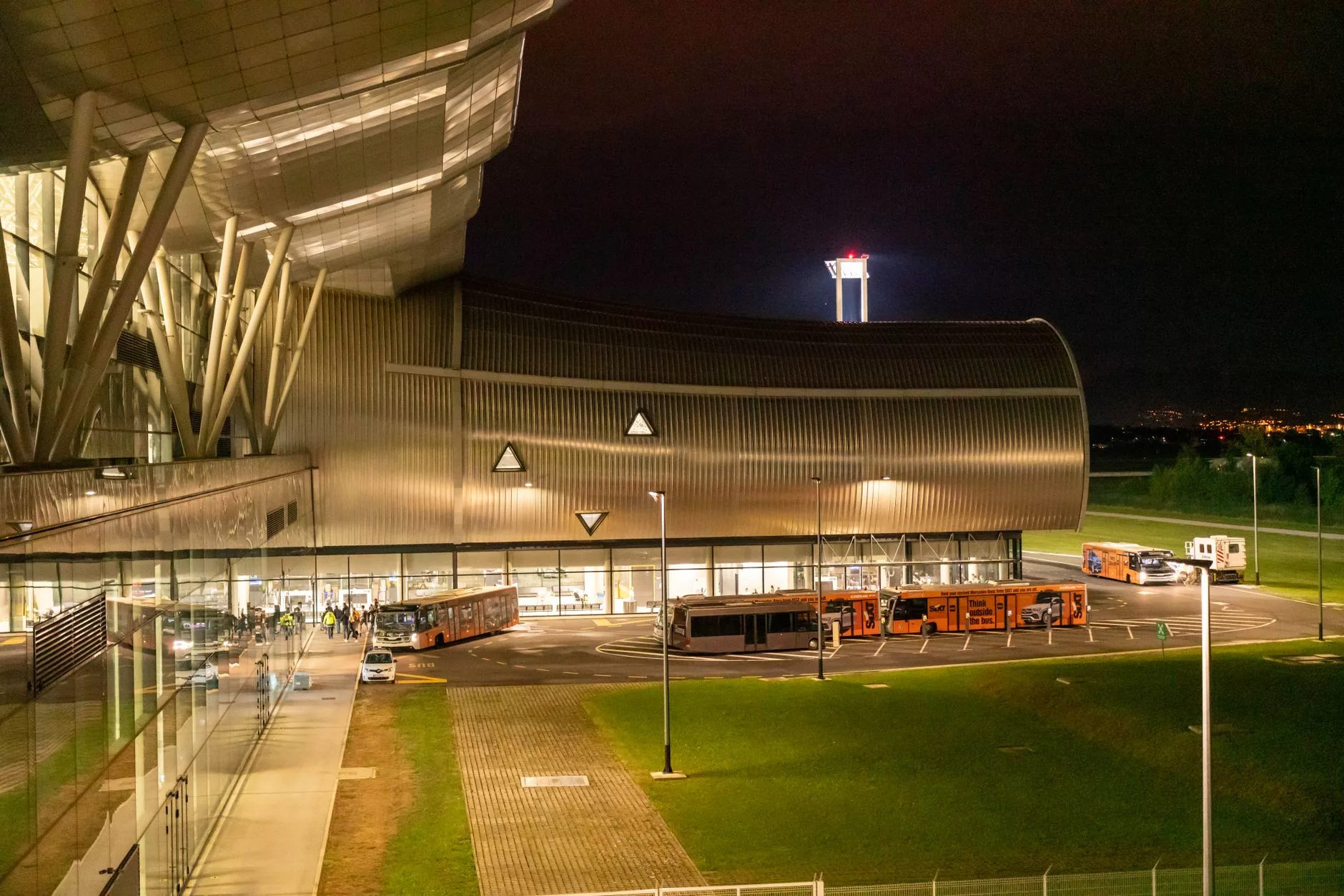 Belgrad Nikola Tesla Havalimanı terminali önünde bekleyen modern kırmızı belediye otobüsleri ve taksiler