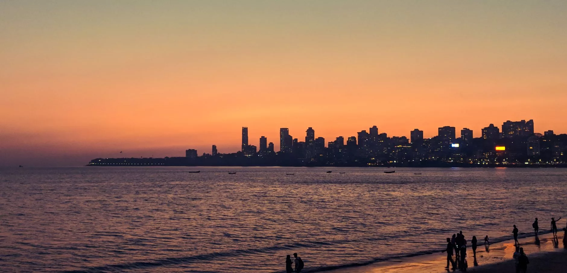 Marine Drive kıyısında yürüyen yerel halk ve gün batımı