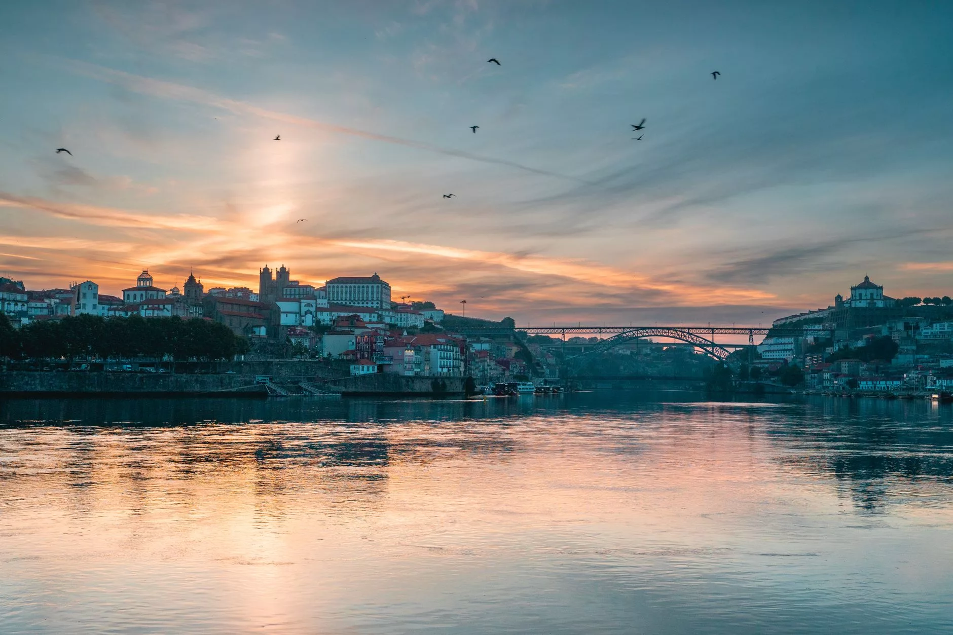 Porto Ribeira rıhtımında gün batımında renkli evlerin duero nehrine yansıması